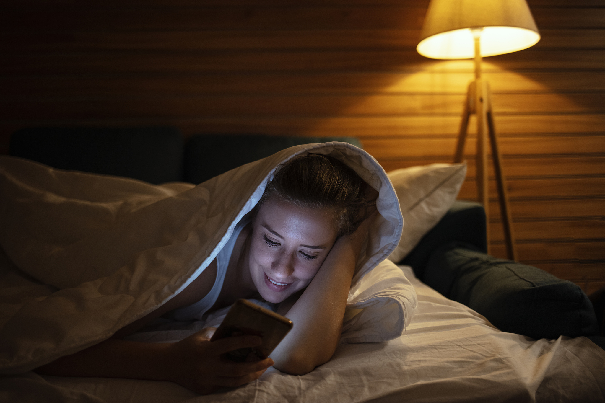 the young woman lay on the bed and phone