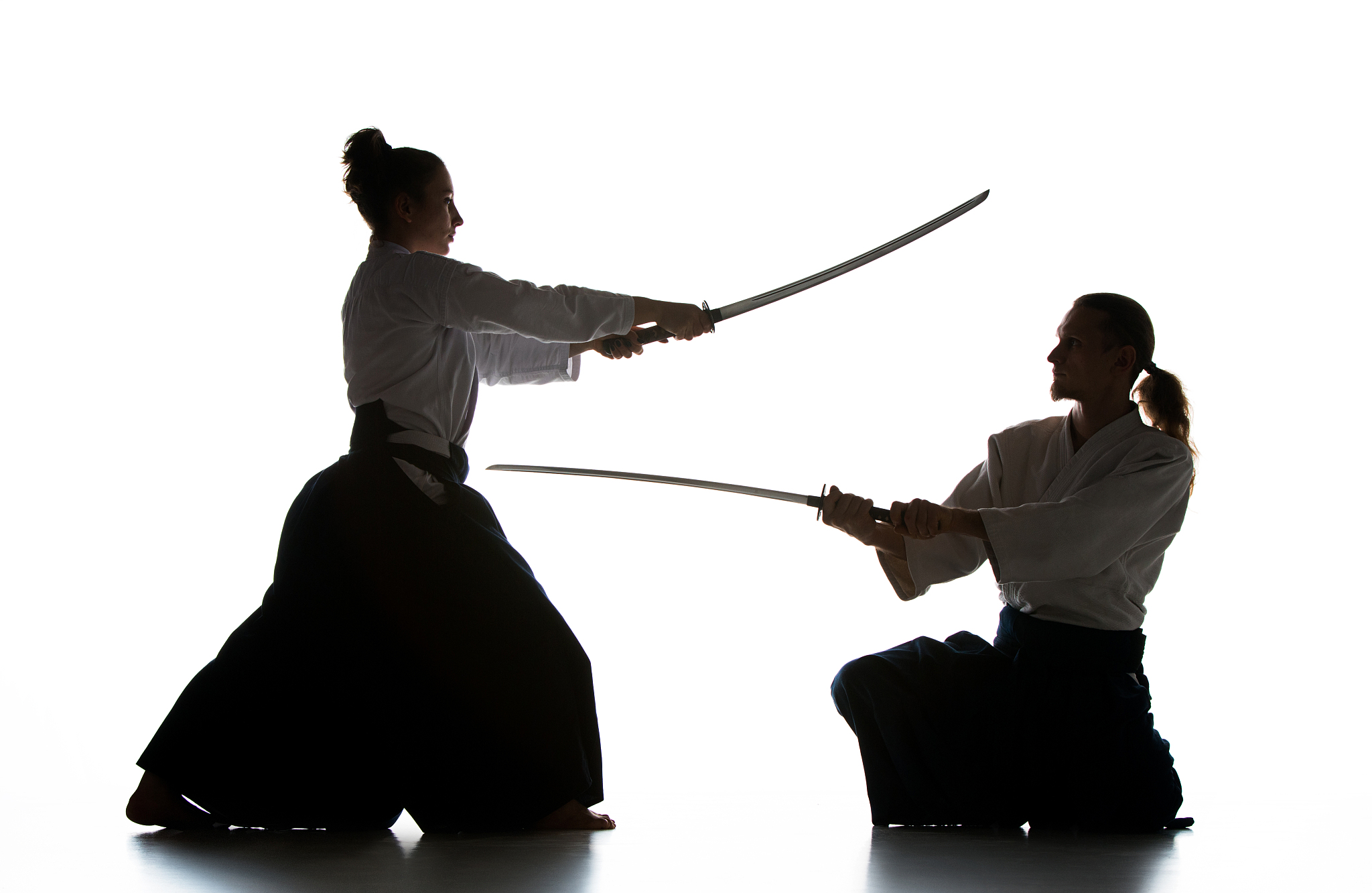 man and woman fighting and training aikido on white studio backg