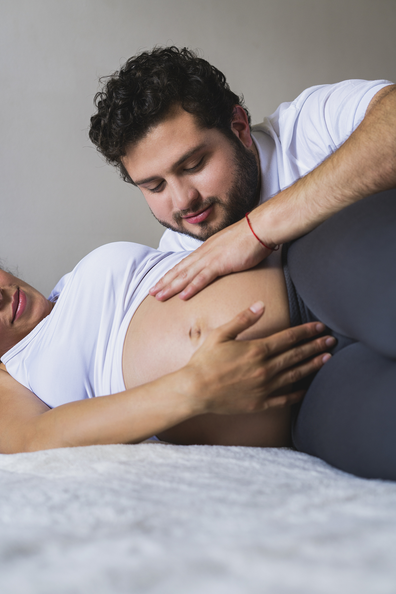 man is touching his wife's pregnancy abdomen