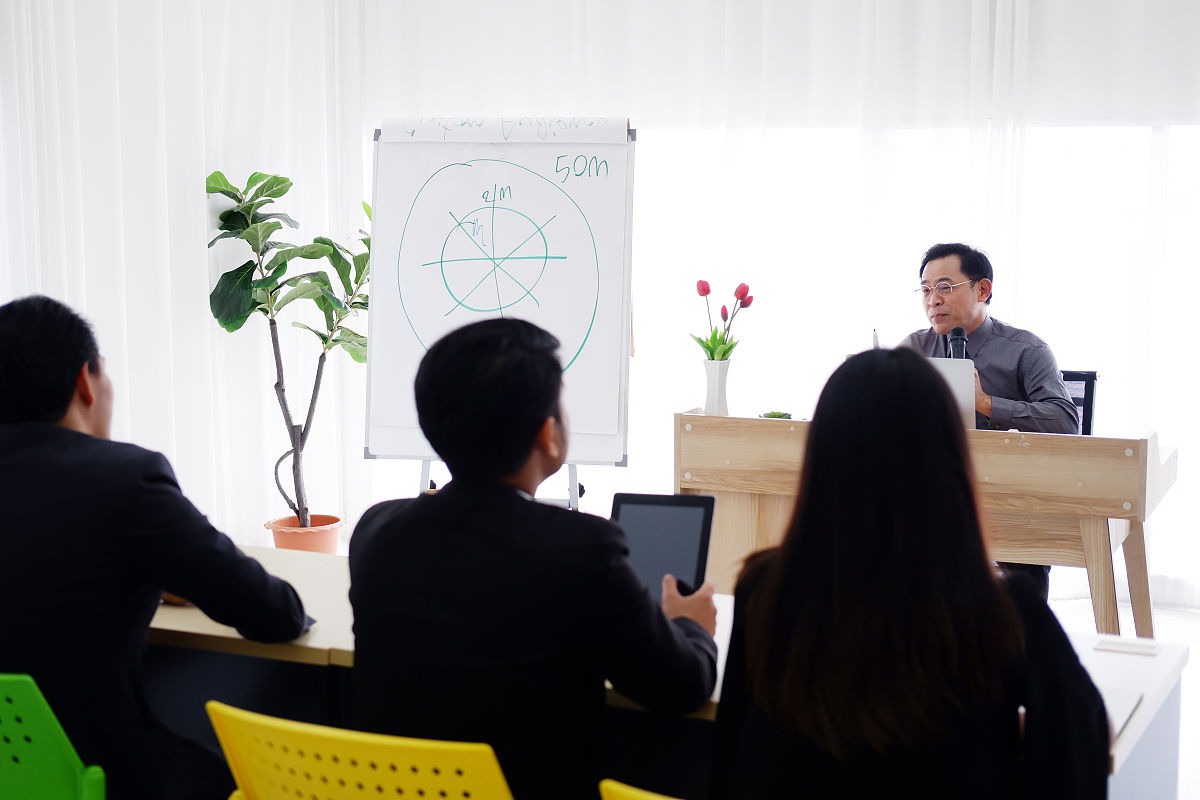 在大学的会议室里,亚洲高级讲师正在谈论商业和股票市场的话题,而商界