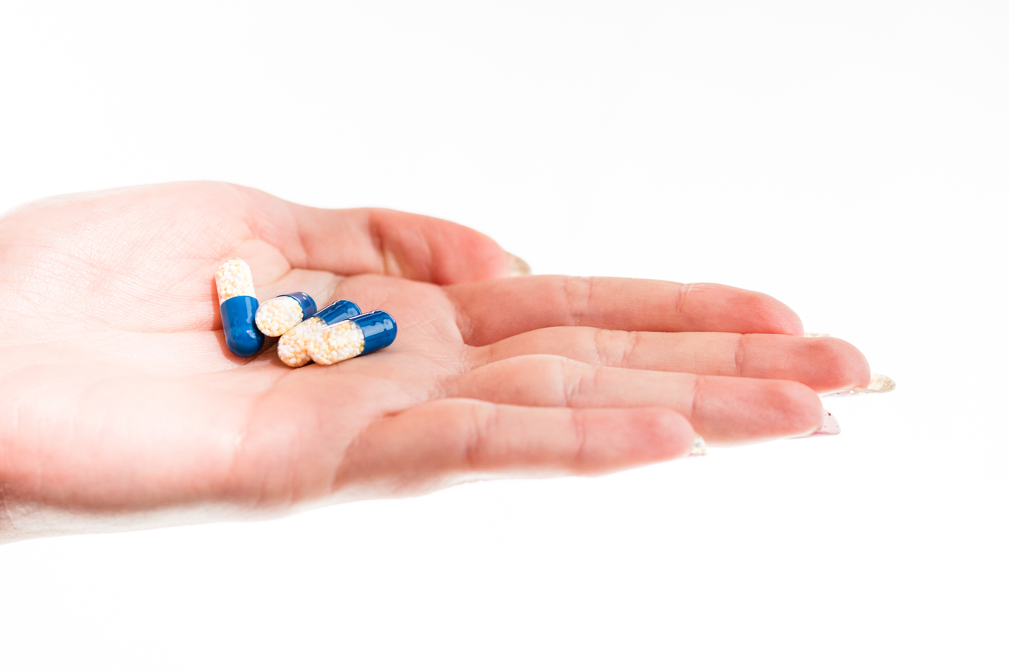 hand holding antibiotics capsules or painkillers isolated on whi