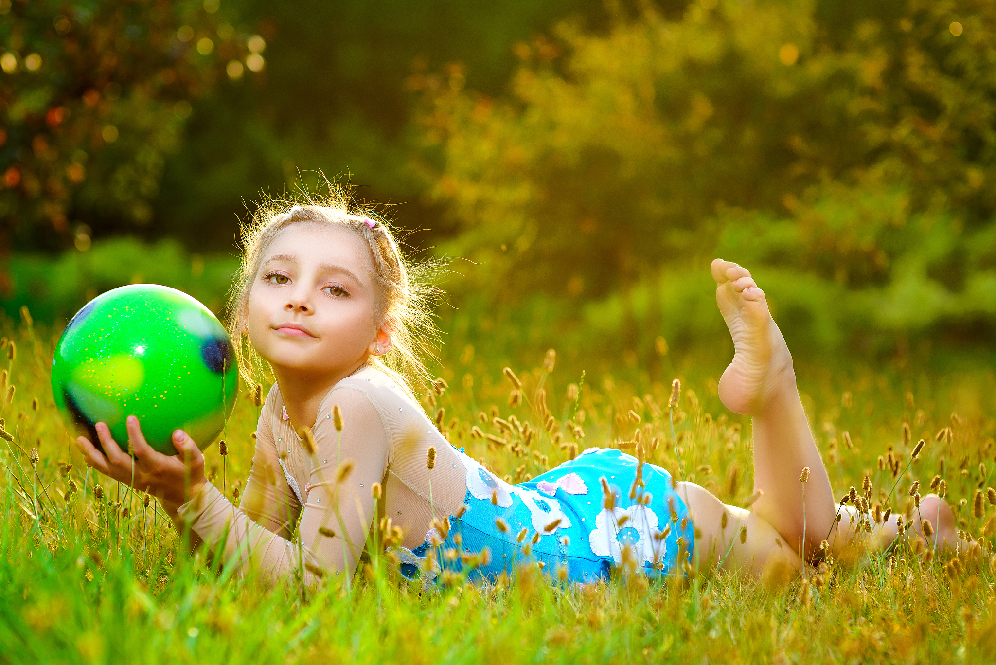 outdoor portrait of young cute little girl gymnast training with