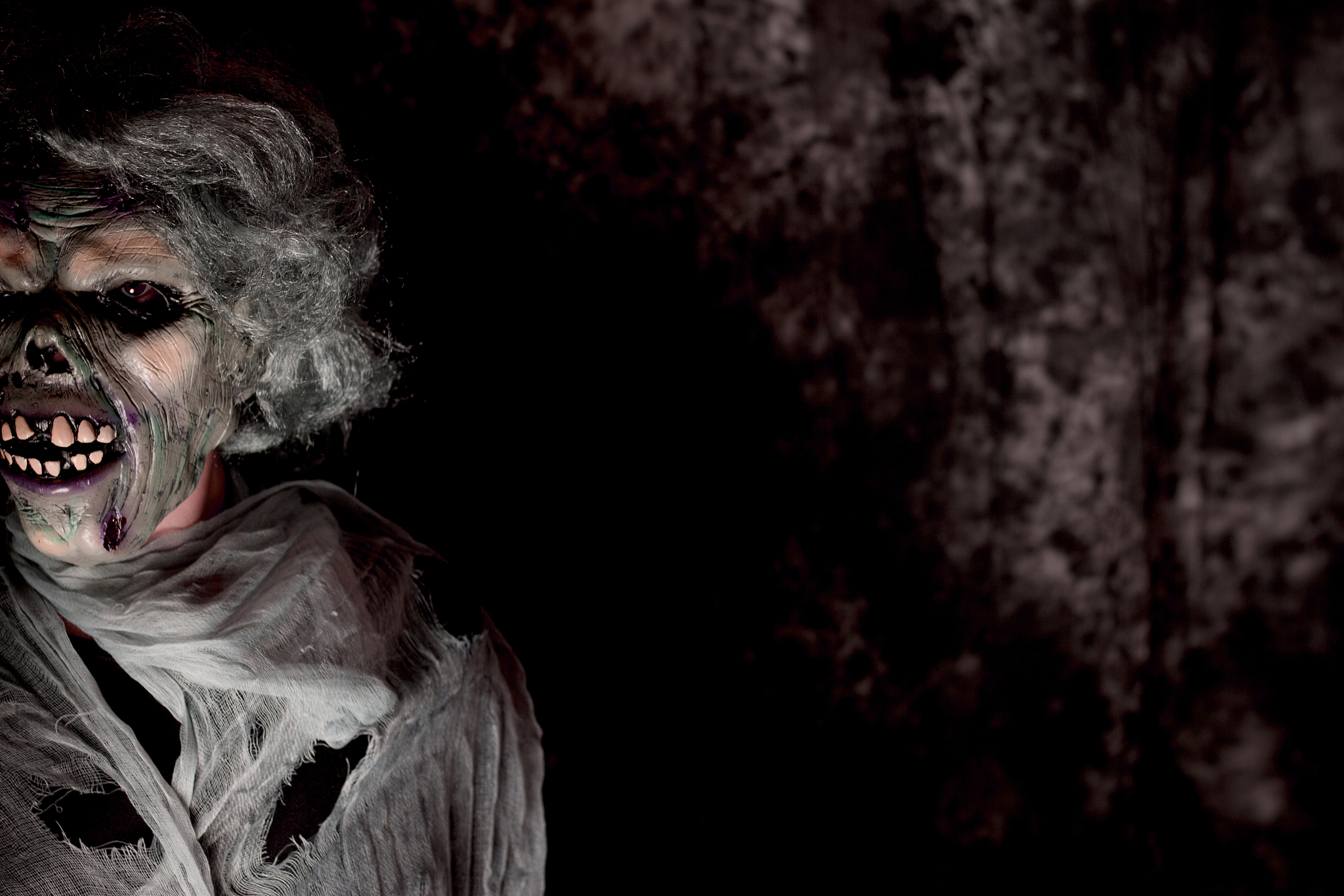 portrait of person in evil mask in darkroom