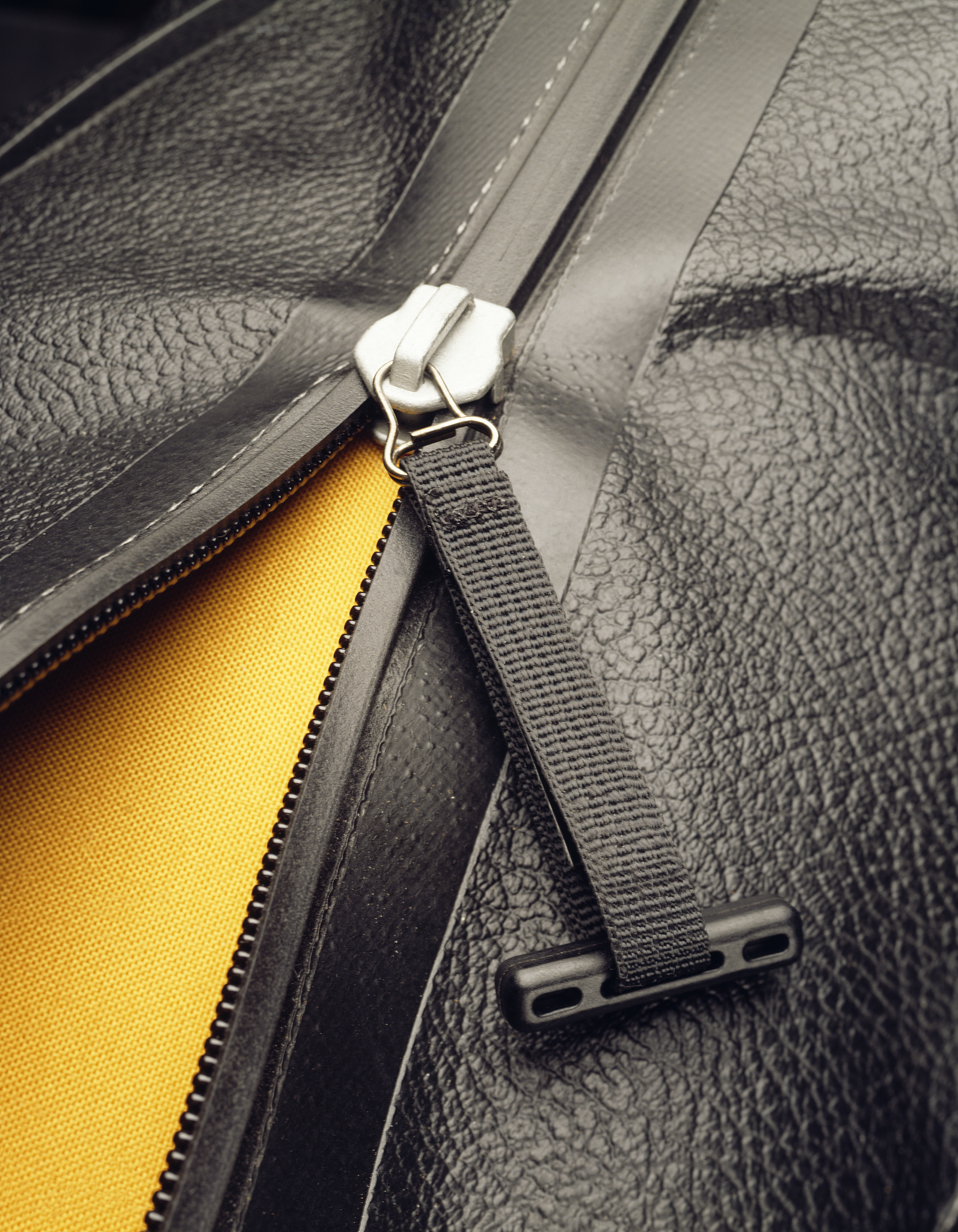 a zipper opening a black leather bag