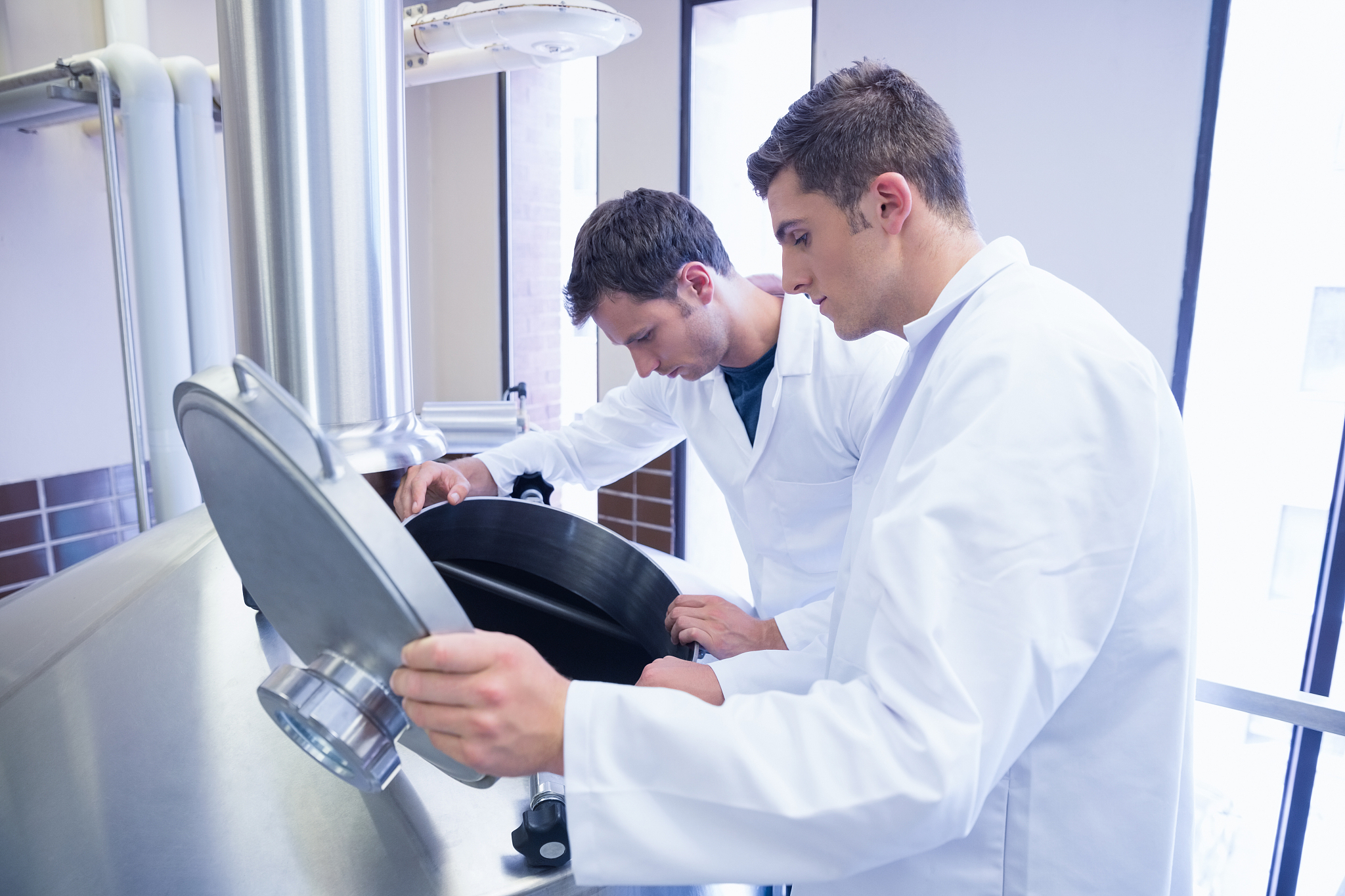 two scientists looking into the container