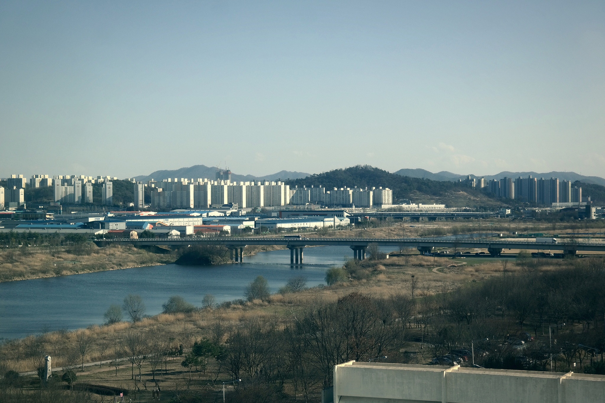 bridge over river in city against clear sky