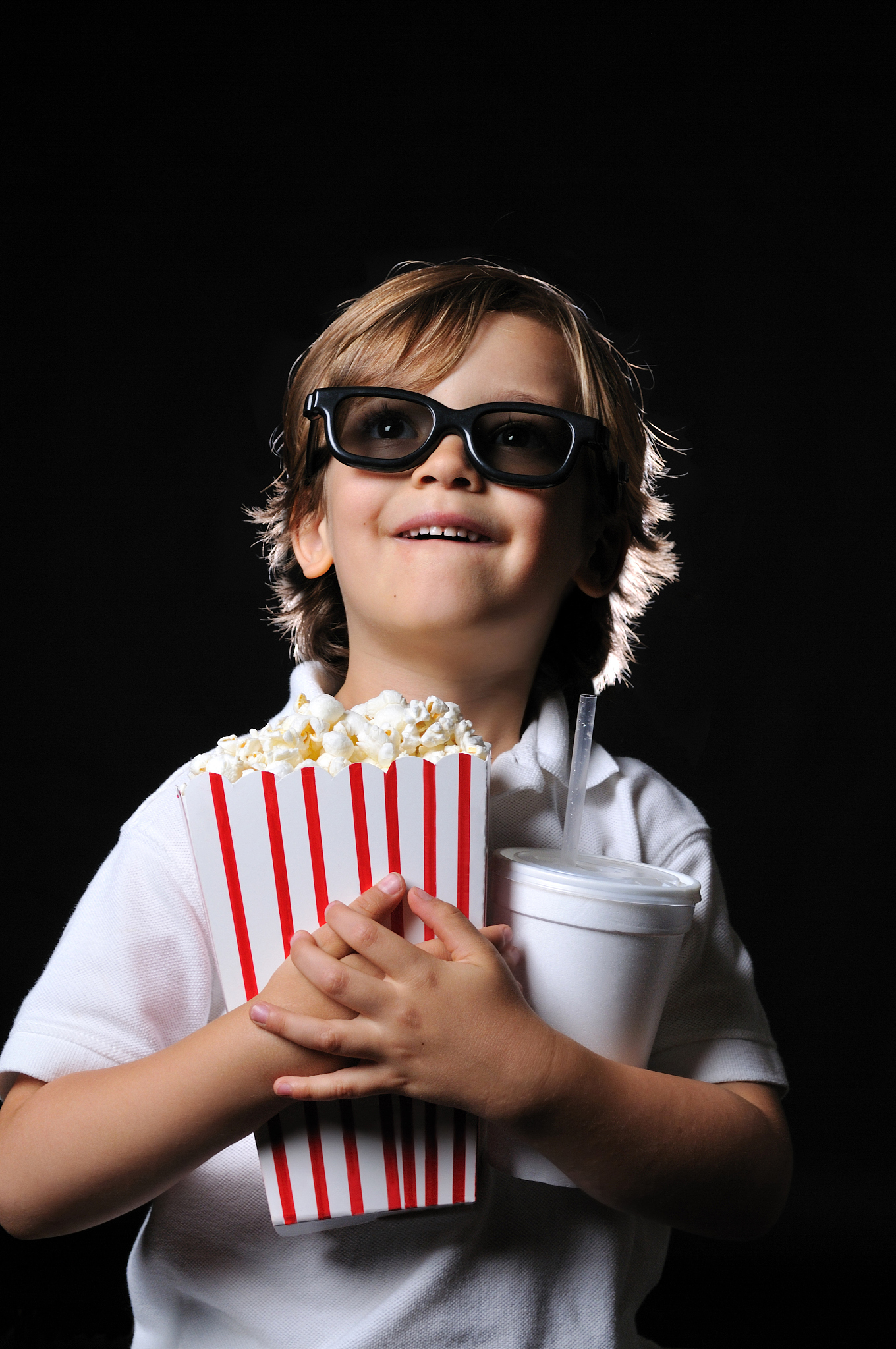excited young boy with 3d glasses on a black background