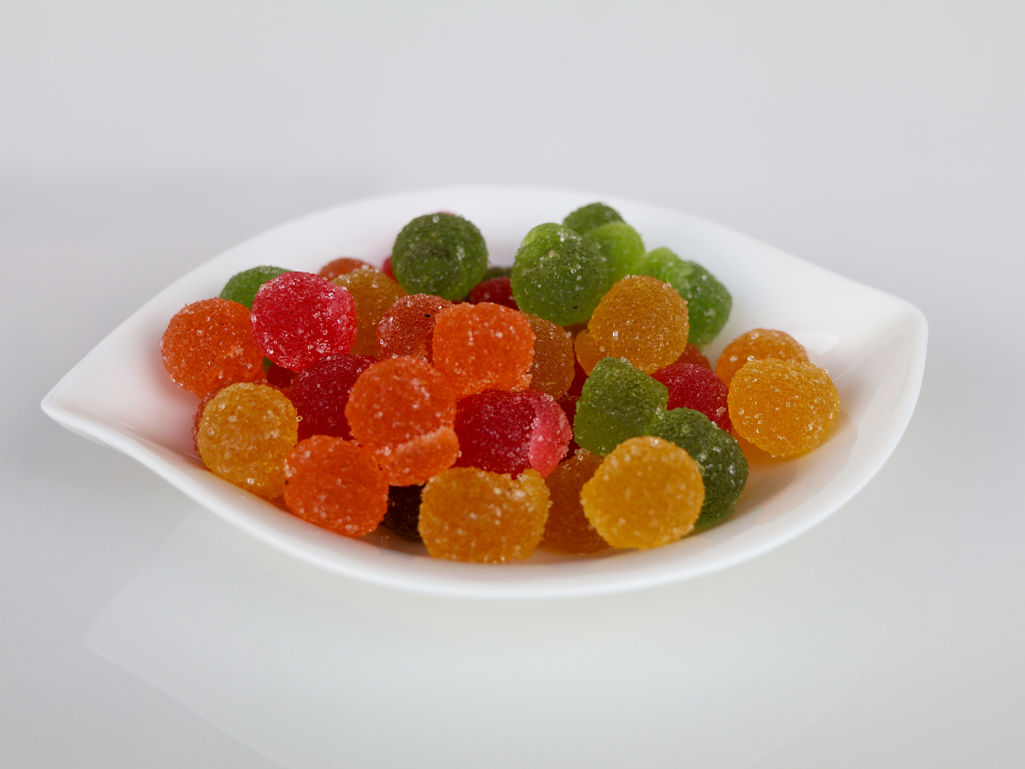 sweet mixed color jelly candy in a white bowl against white back