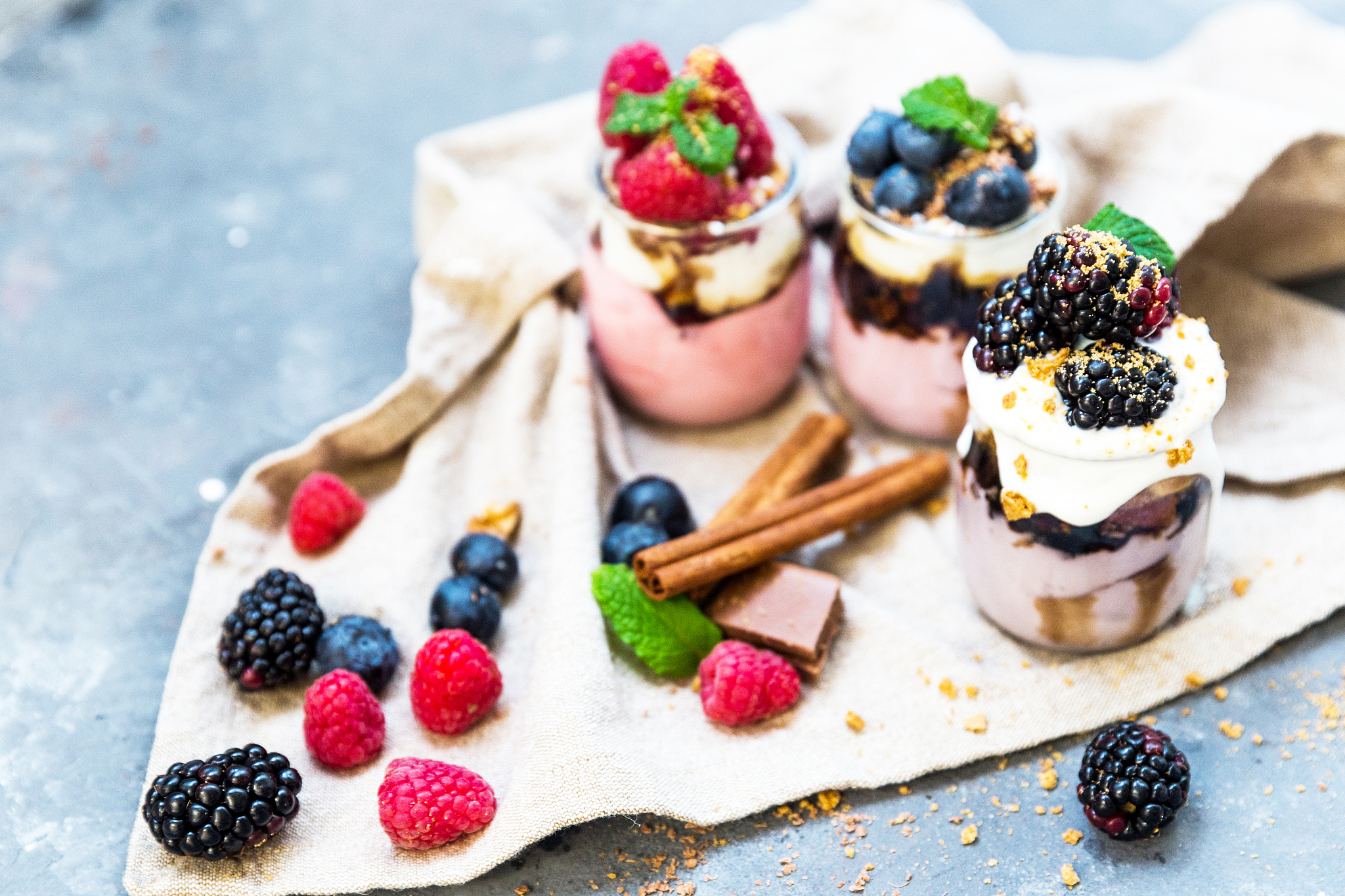 sweet dessert in glass with biscuit, berry fruit and whipped cre