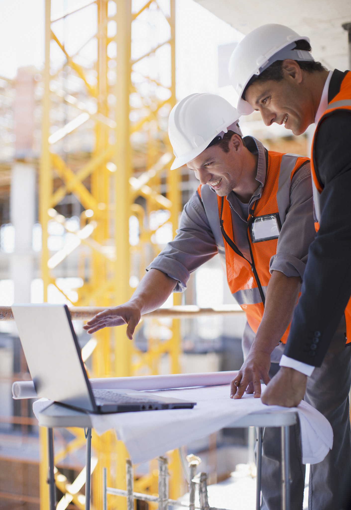 construction workers using laptop on construction site