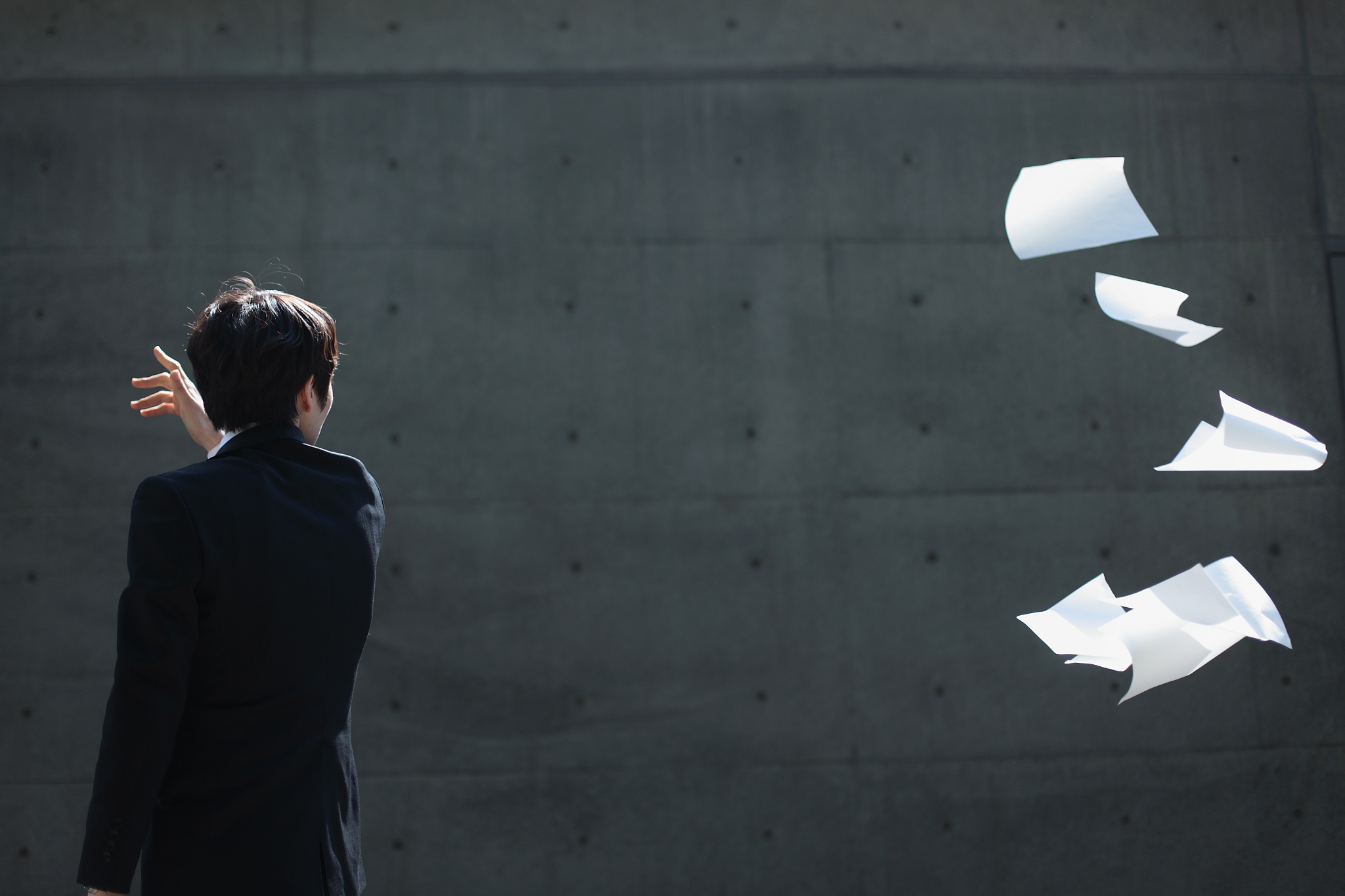 young businessman throwing sheets of paper