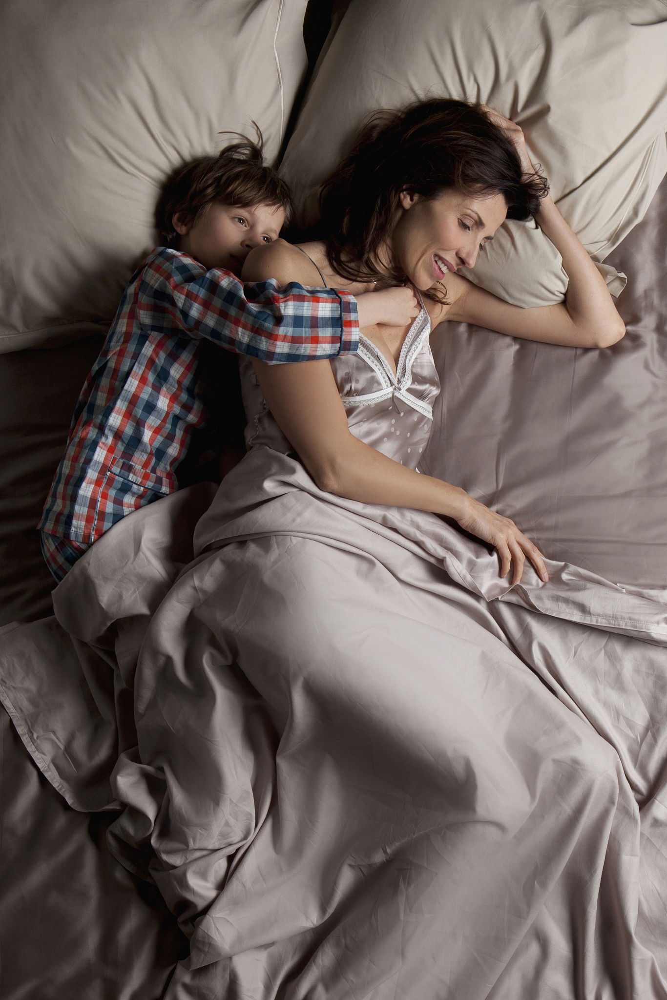 woman lying in a bed with her children