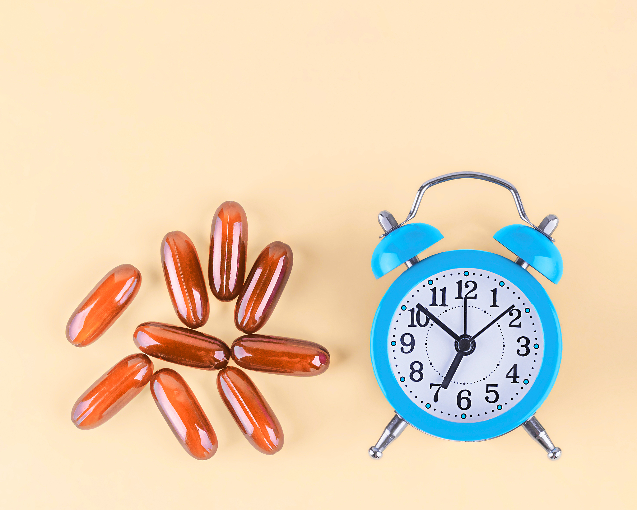 alarm clock and capsules with vitamins.