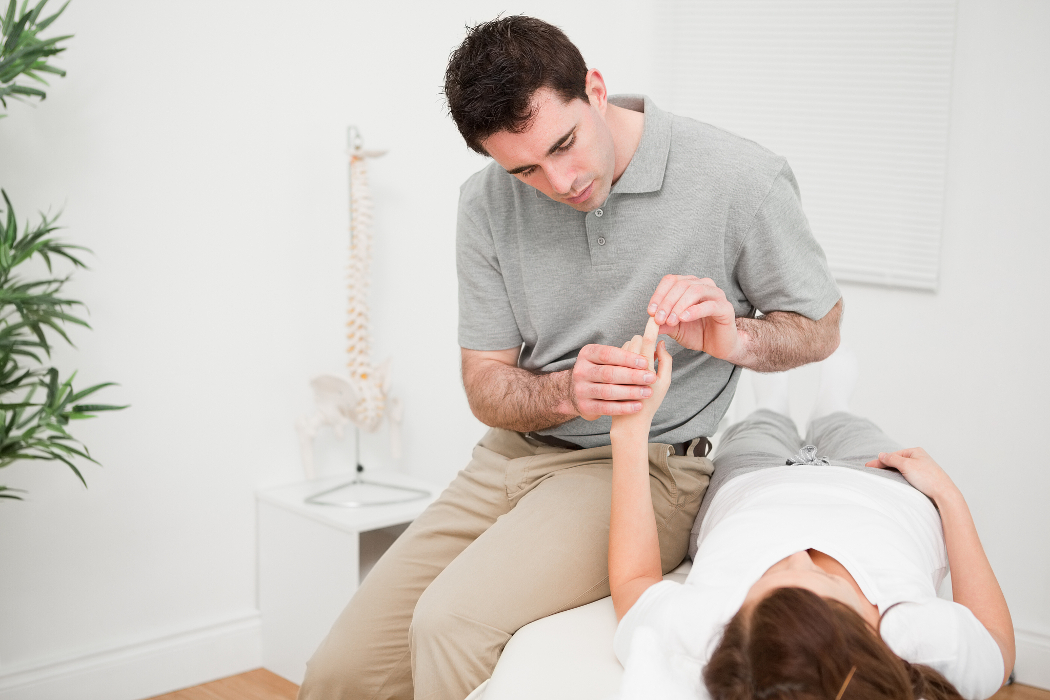 physiotherapist moving the forefinger of a patient
