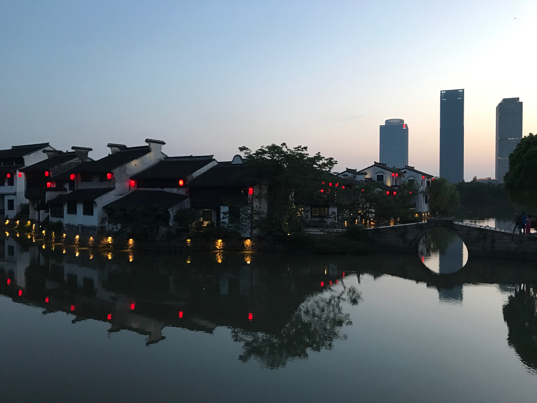 reflection of city in water against clear sky