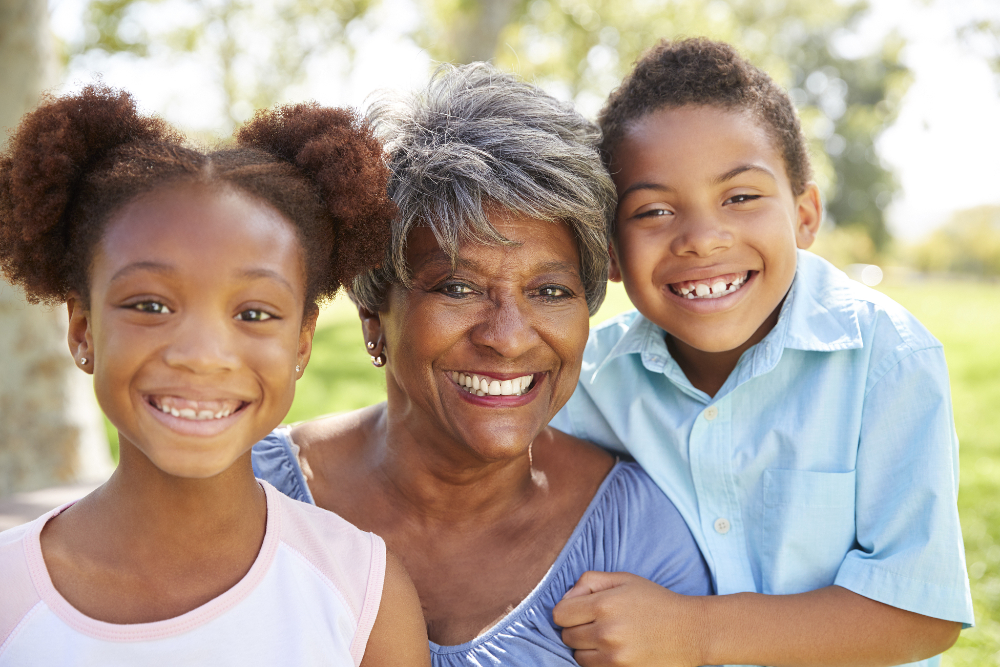portrait of grandmother with grandchildren relaxing in park