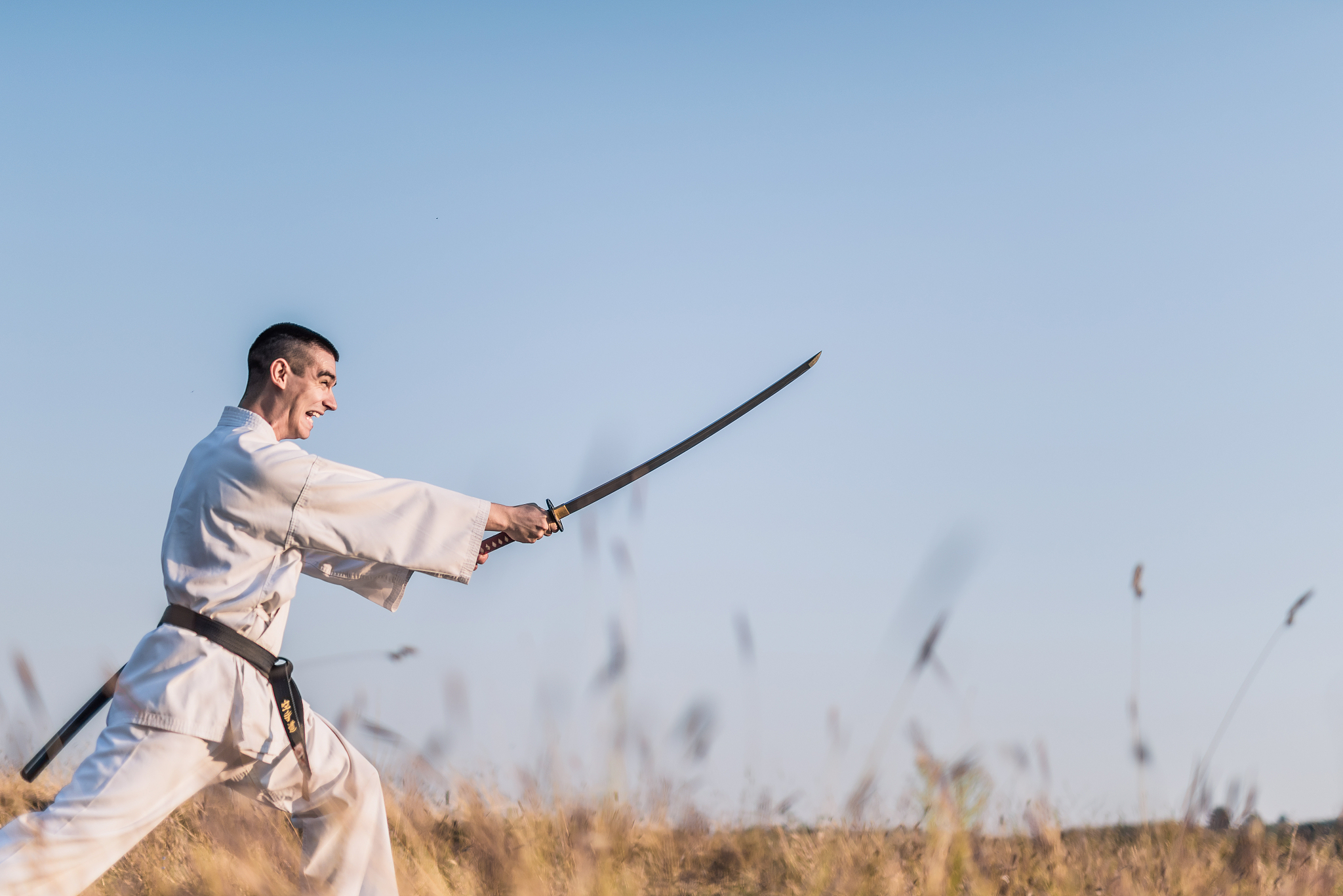 young martial artist practicing skills with samurai sword on a r