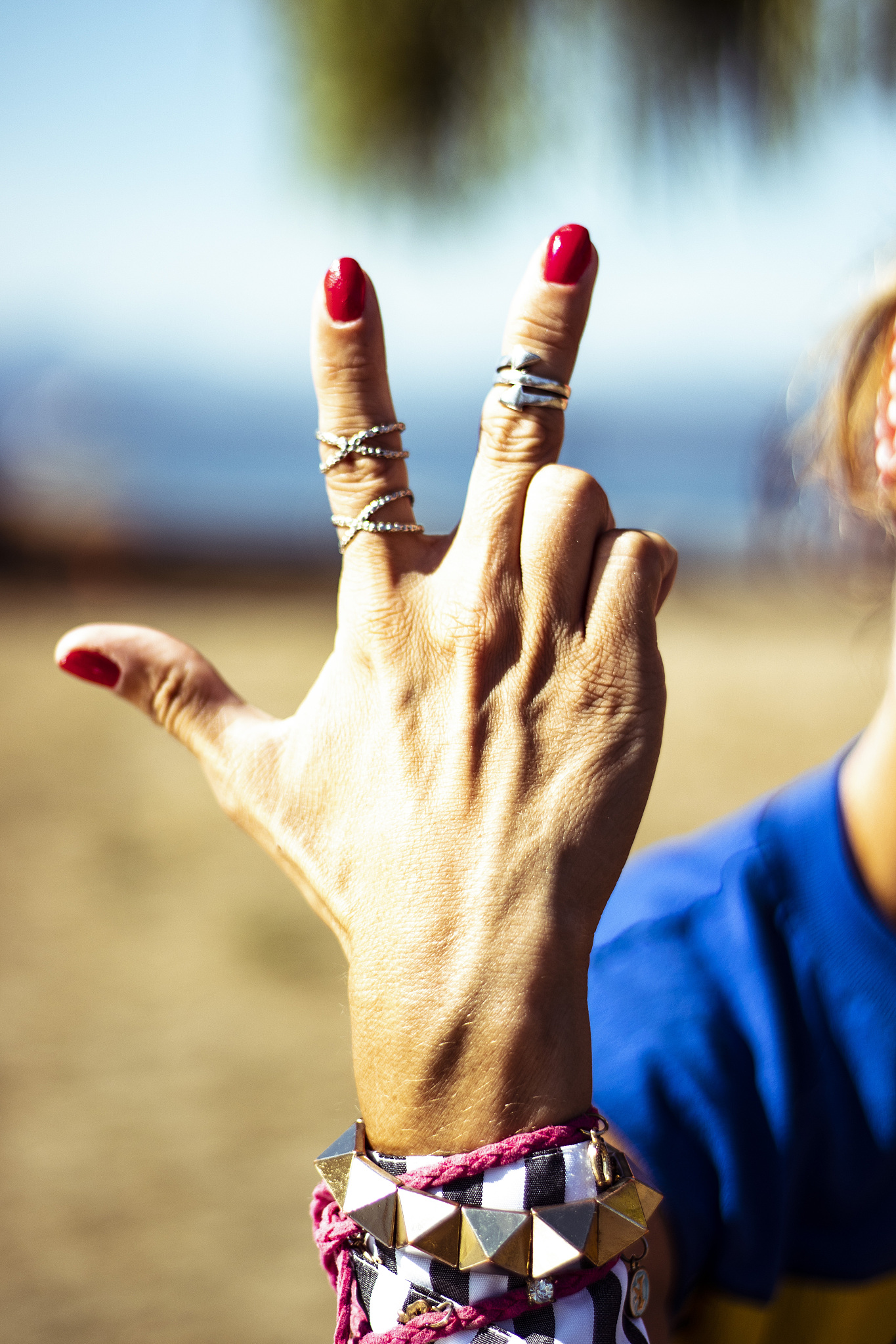 woman showing her hand with number three counting red nails poli