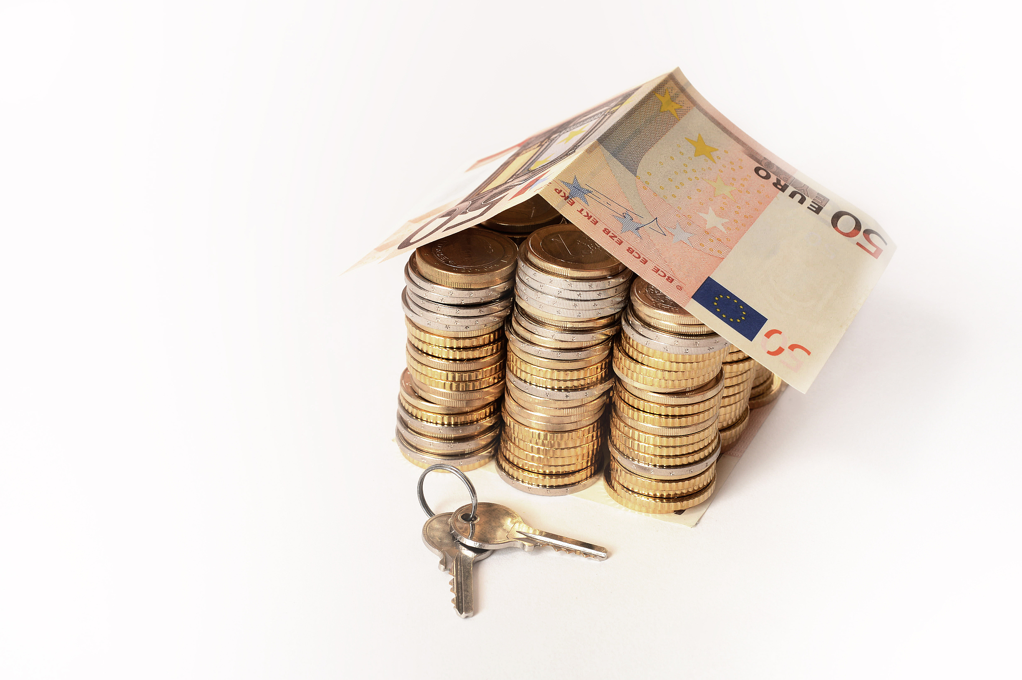 euro coins pile house with banknote roof and key