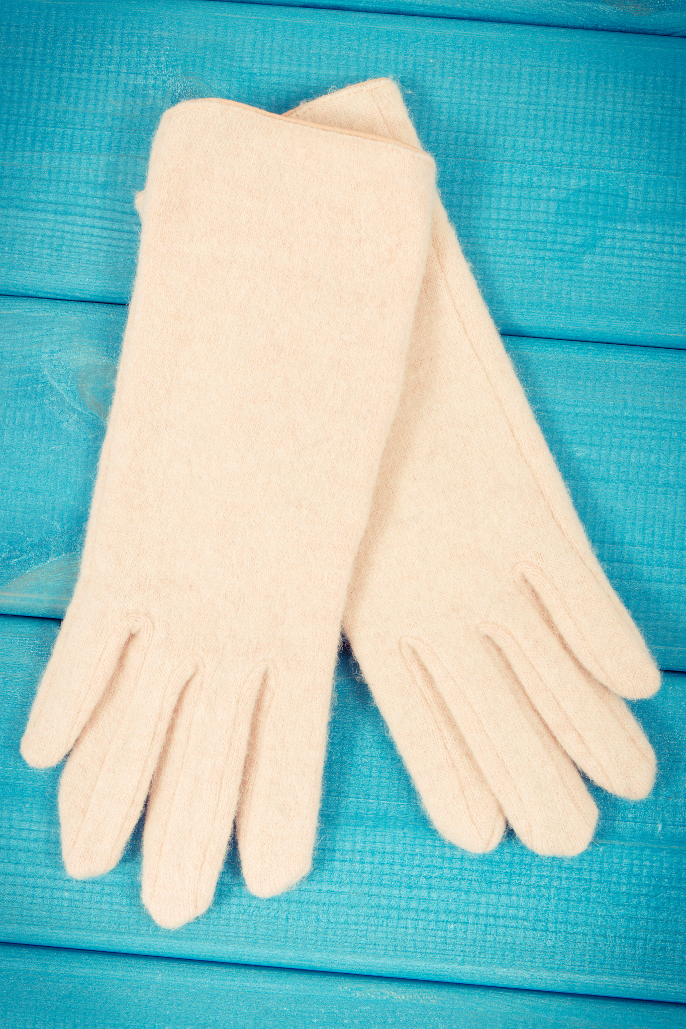 womanly mittens for autumn or winter on blue board