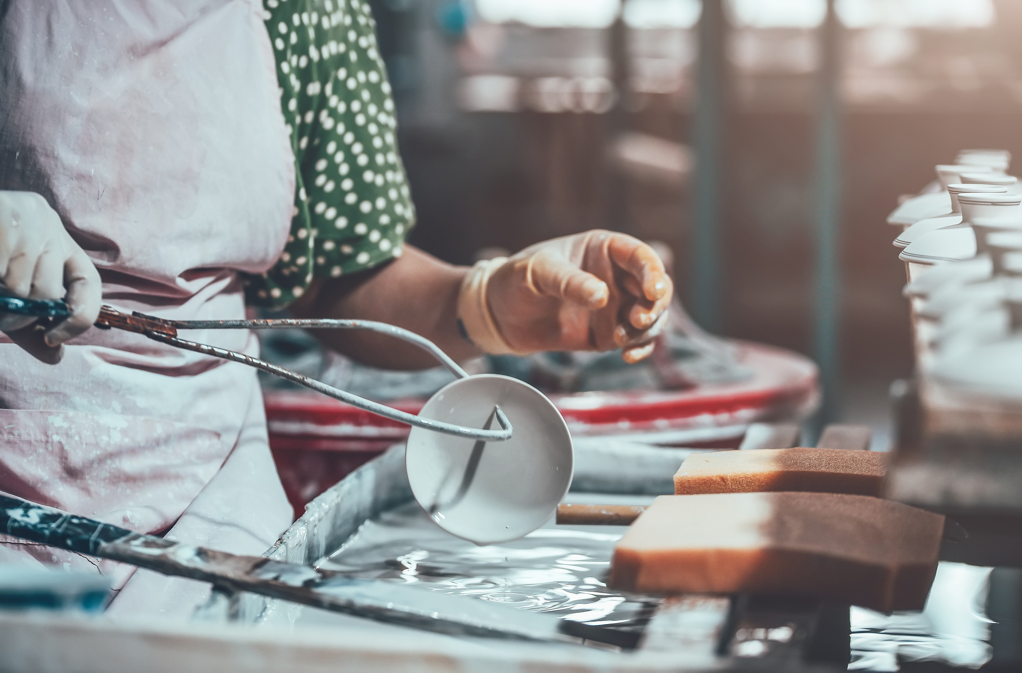 glazing a porcelain cup in a factory