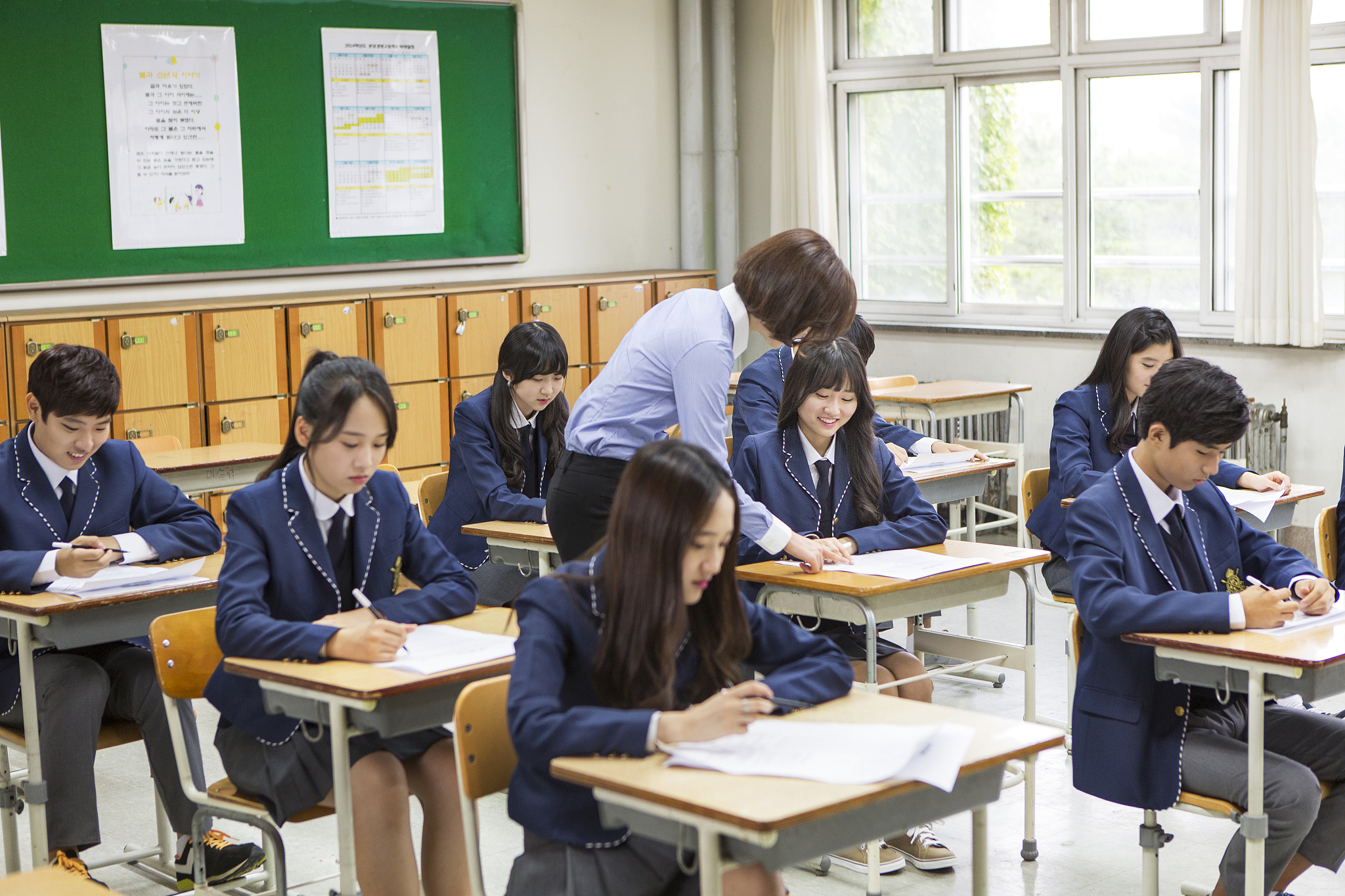 photography of teacher and students taking exam in the classroom
