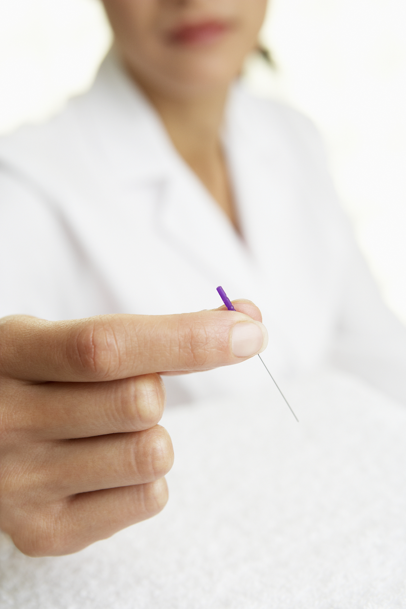 asian woman holding acupuncture needle