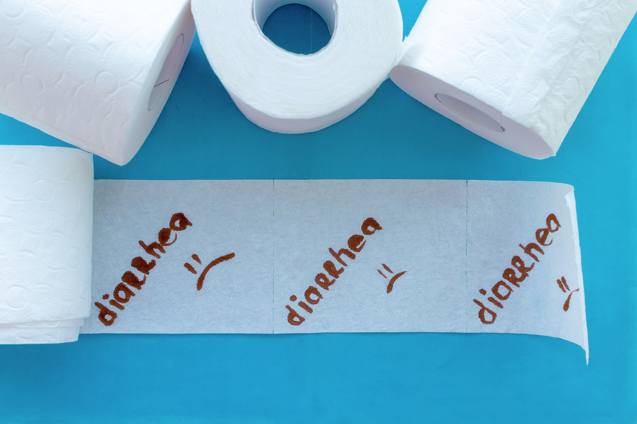 rolls of white toilet paper labeled "diarrhea" on a blue backgro