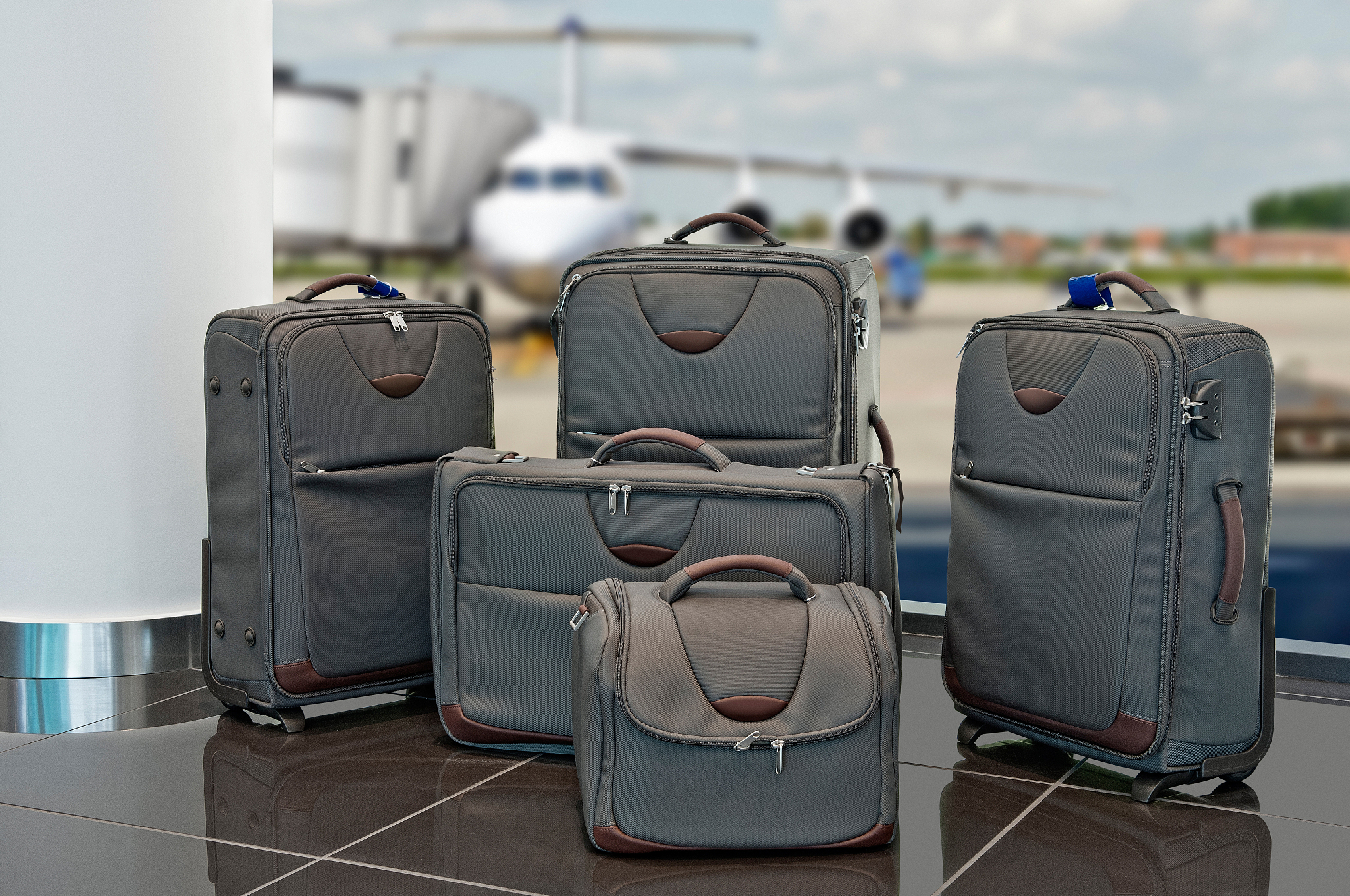lot of travel luggage set with airplane in background