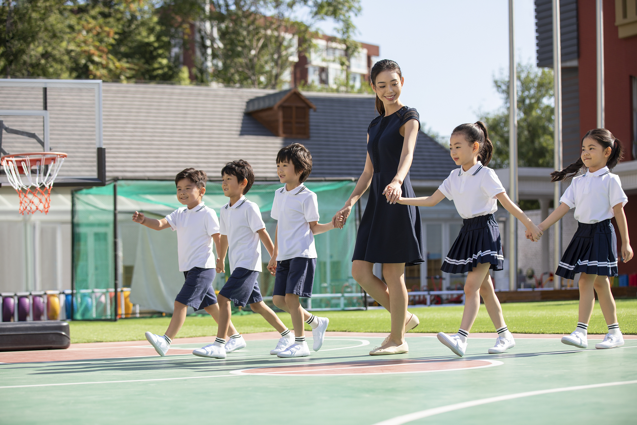 幼儿园老师和学生在操场上