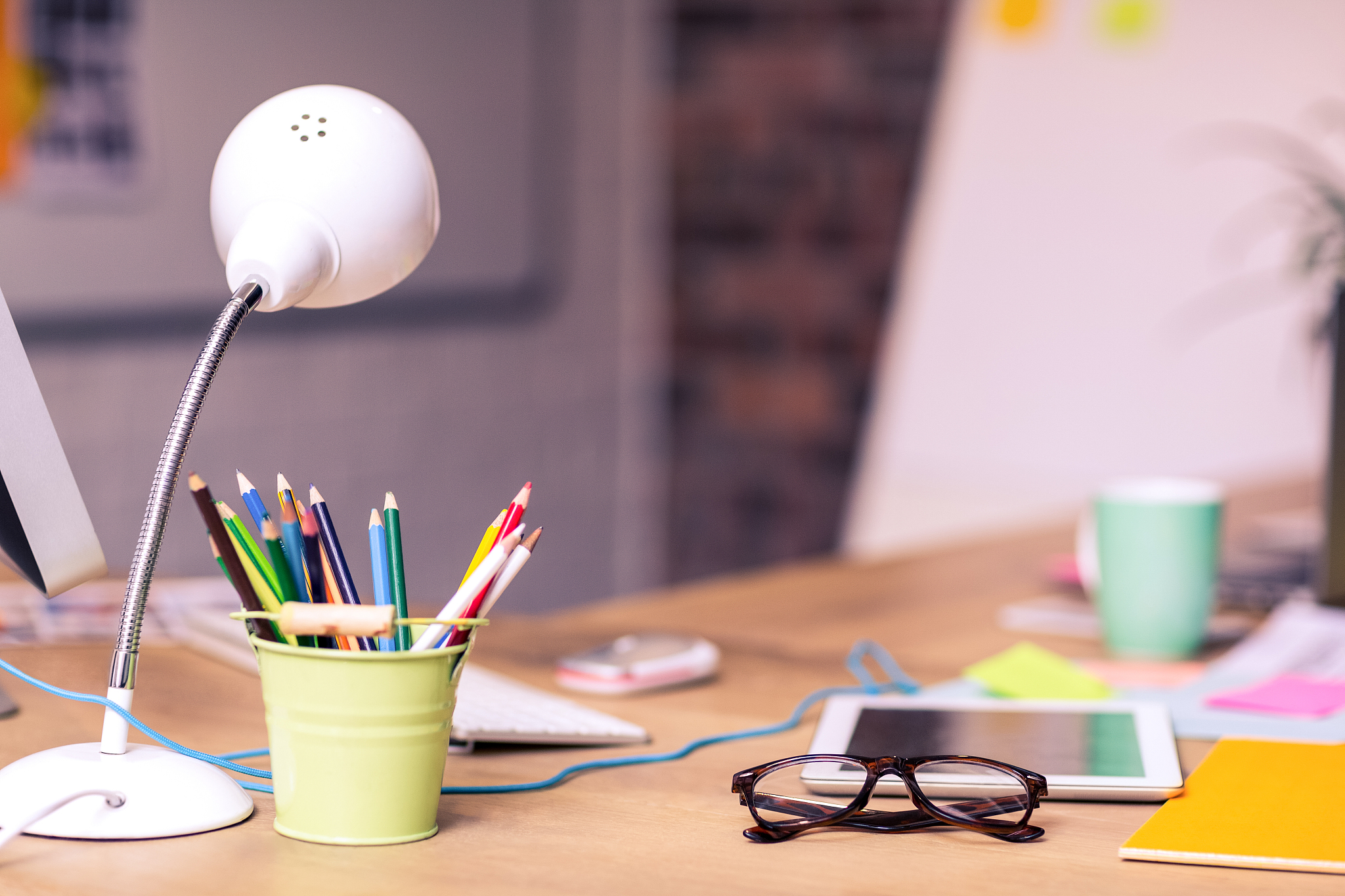 digital tablet, spectacles and penholder on a table