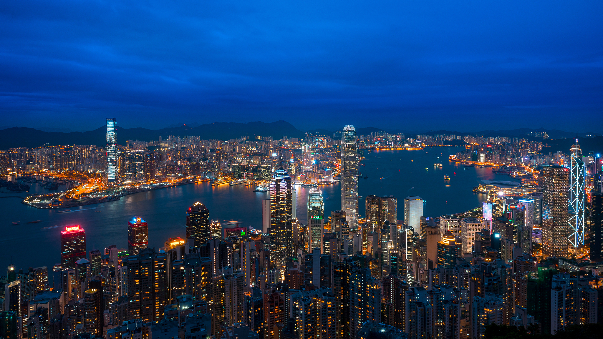 illuminated cityscape against blue sky at night