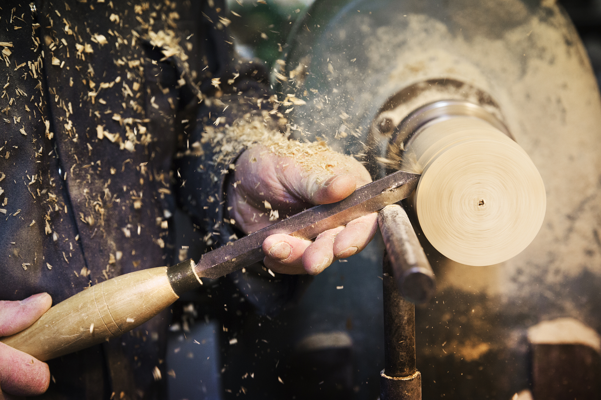 man standing at a woodworking machine in a carpentry workshop, t