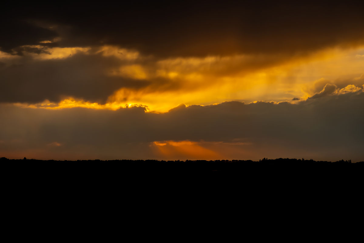 夕阳西下，如破碎蛋黄，金黄山稠汁流淌与乌云交融