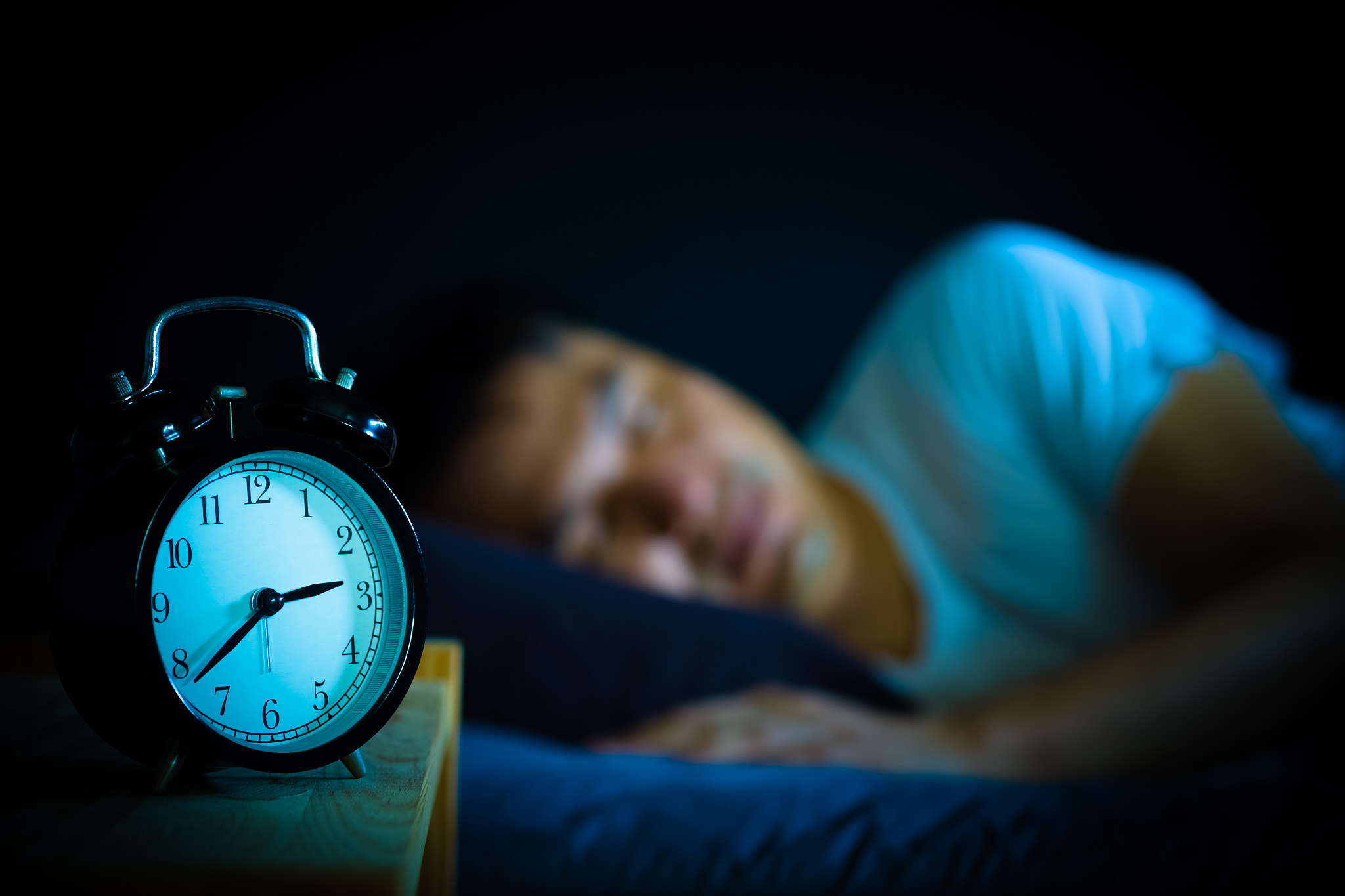 sleeping asian man in bed at night