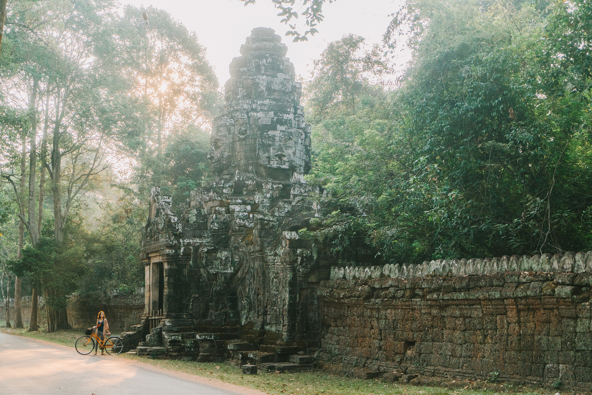 young caucasian woman standing  with bicycle  in angkor wat