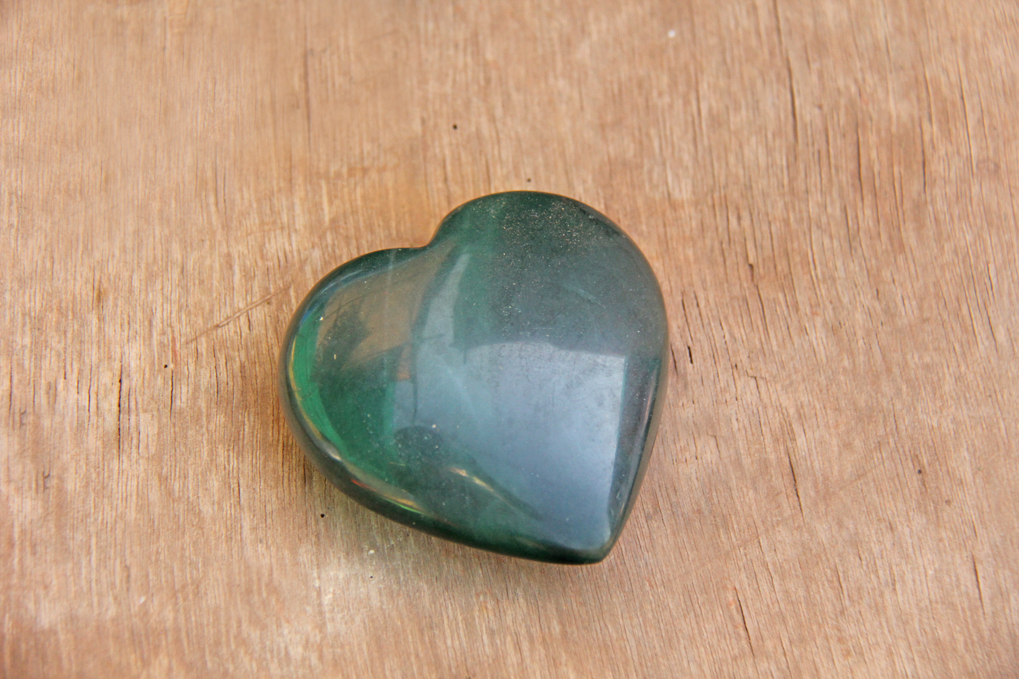 green heart made of natural stone jade. a heart shaped stone lie