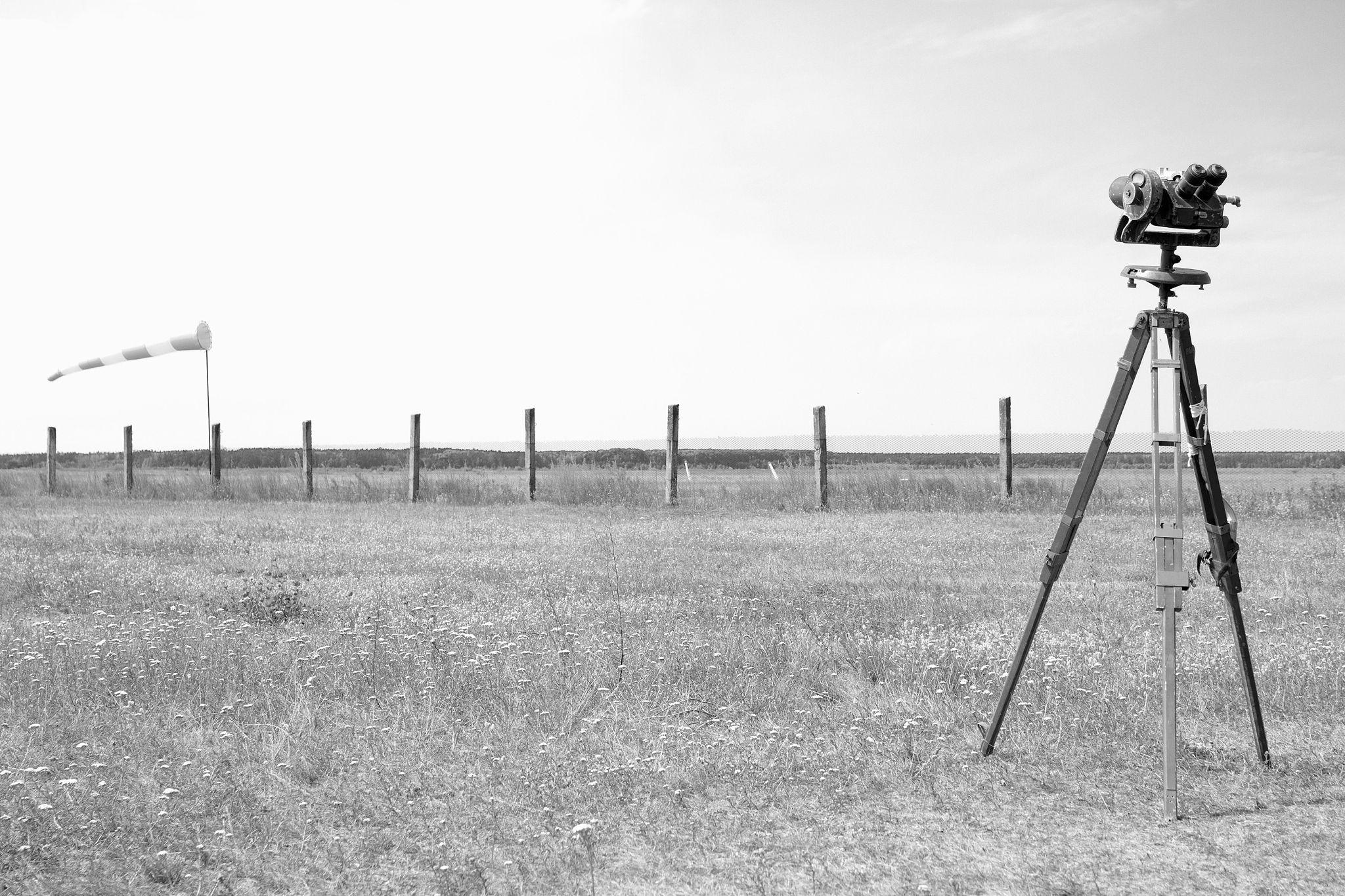 red-white windsock and geodetic instruments on the airfield.