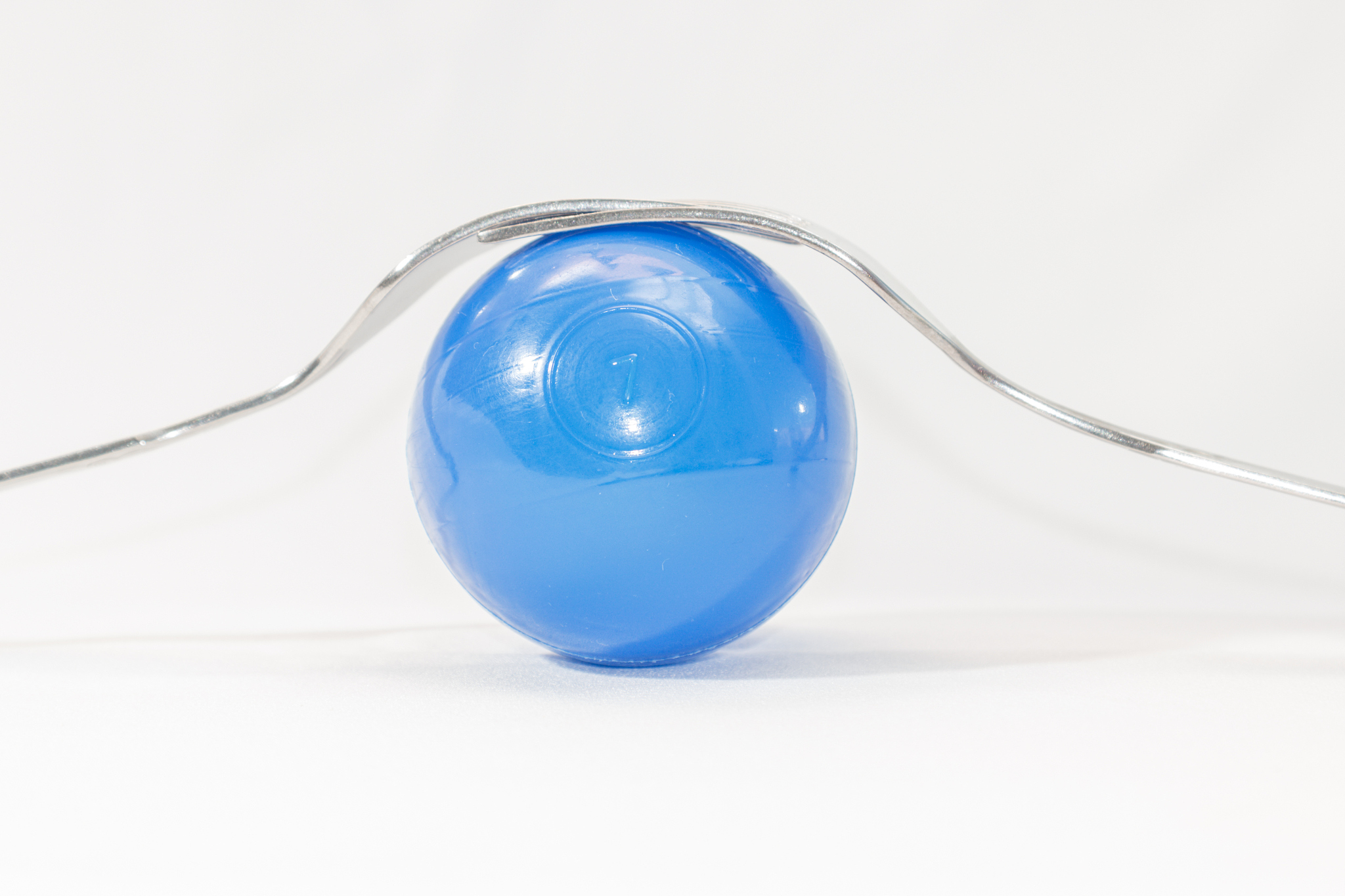 two forks and colored balls on a white background