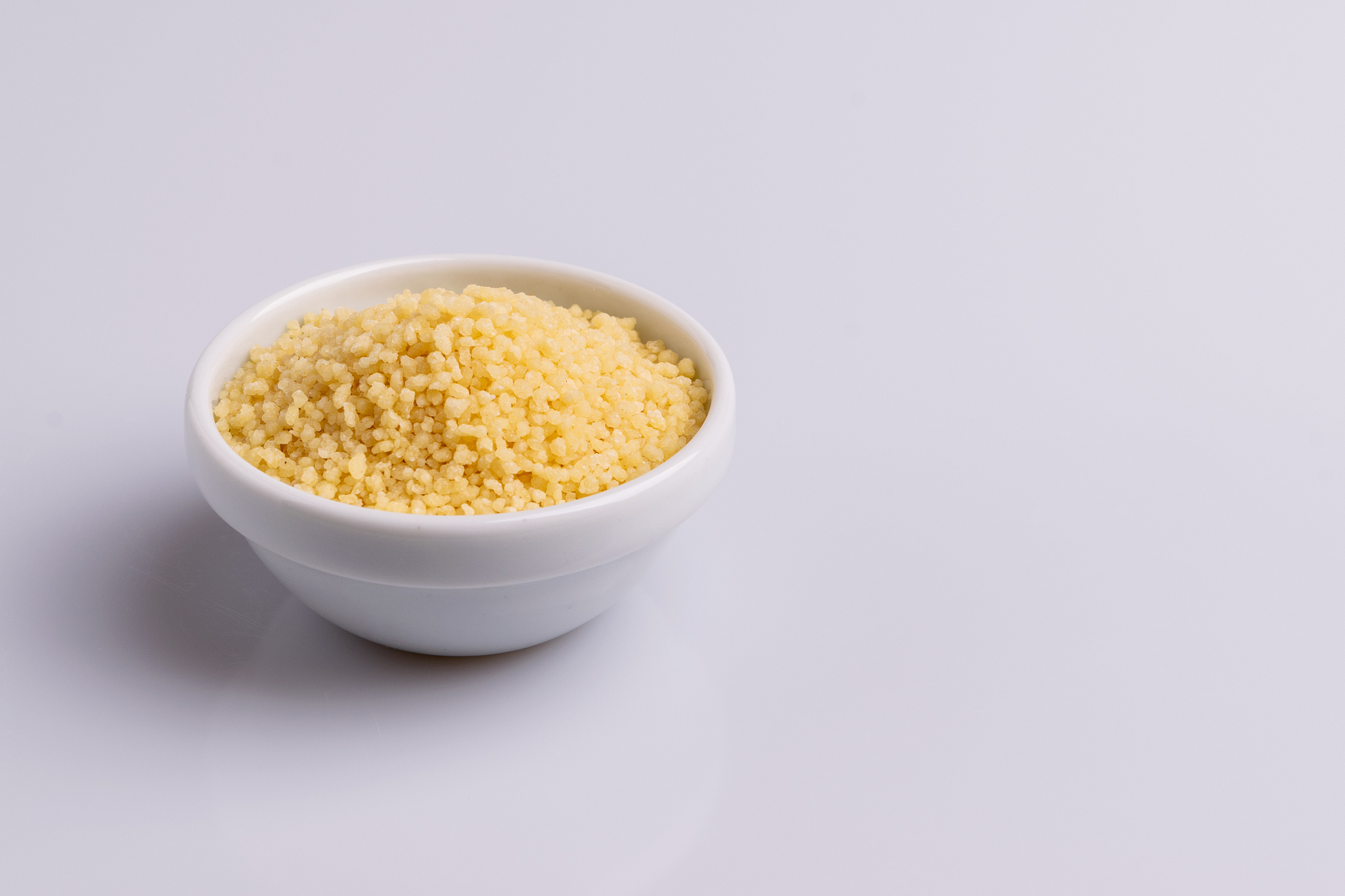 dry couscous isolated on white background, soft light, copy spac