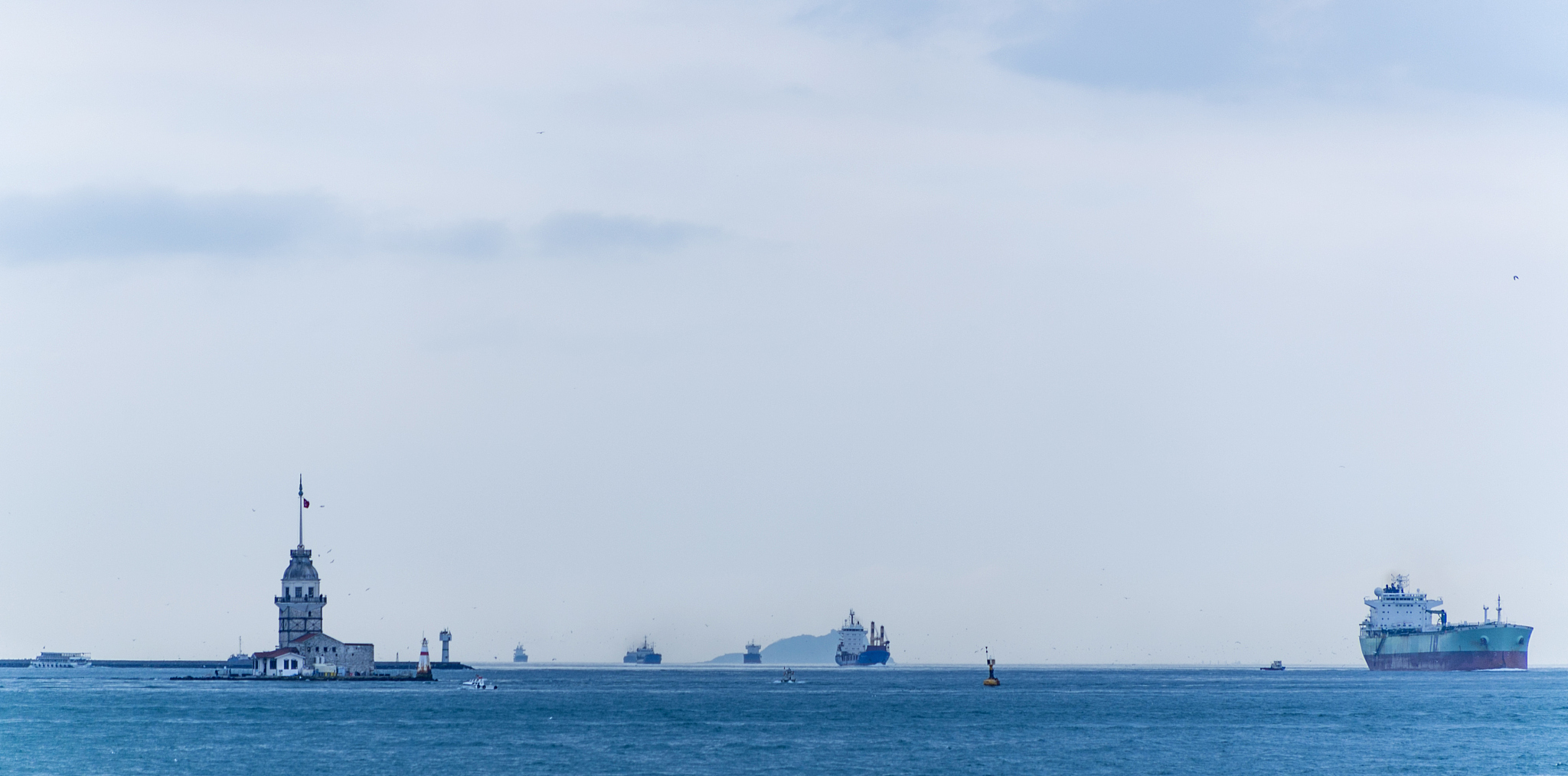 industrial ships are passing by historical maiden tower at middl
