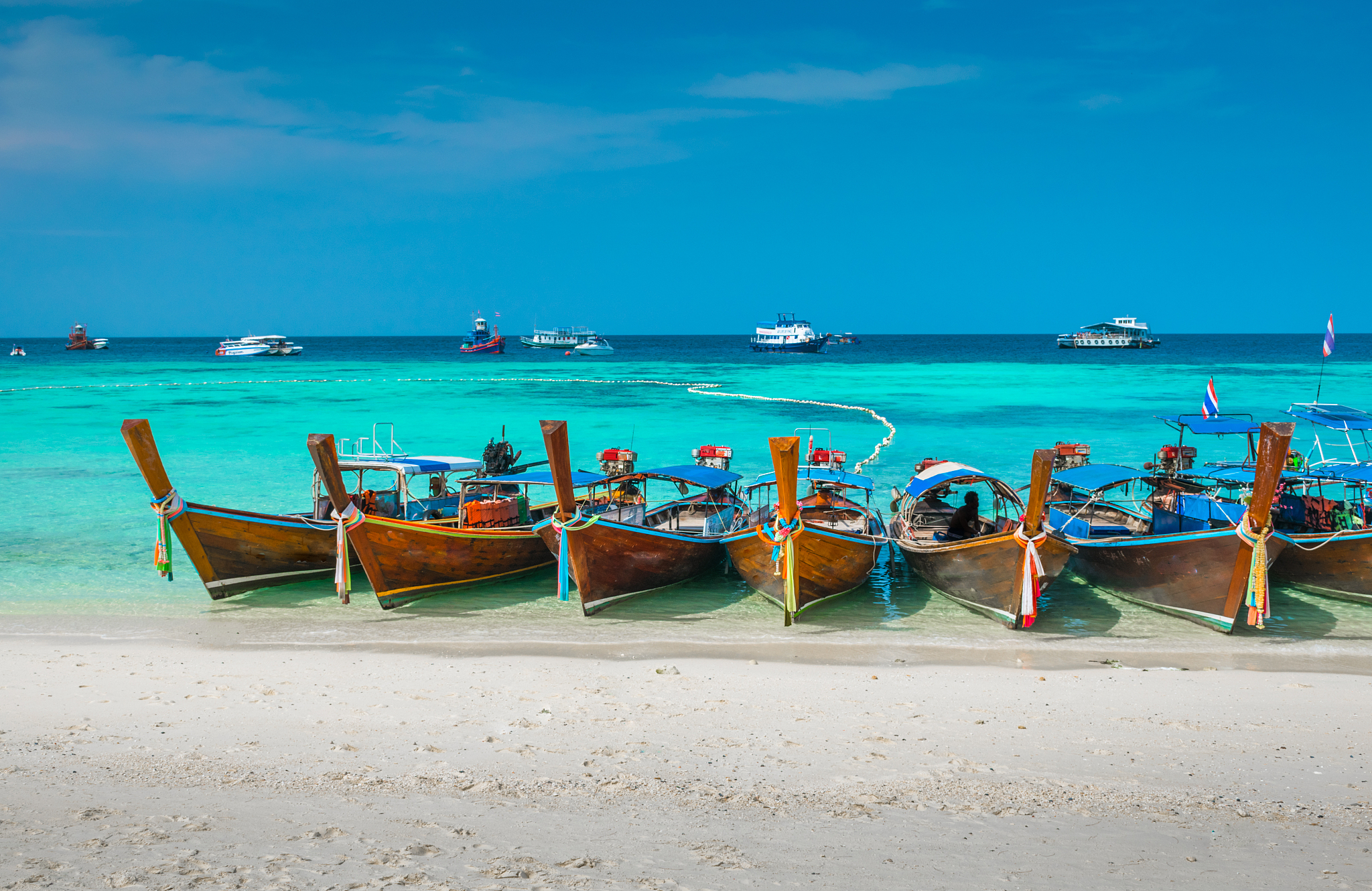beautiful longtail boats moored on beach at koh lipe against sky