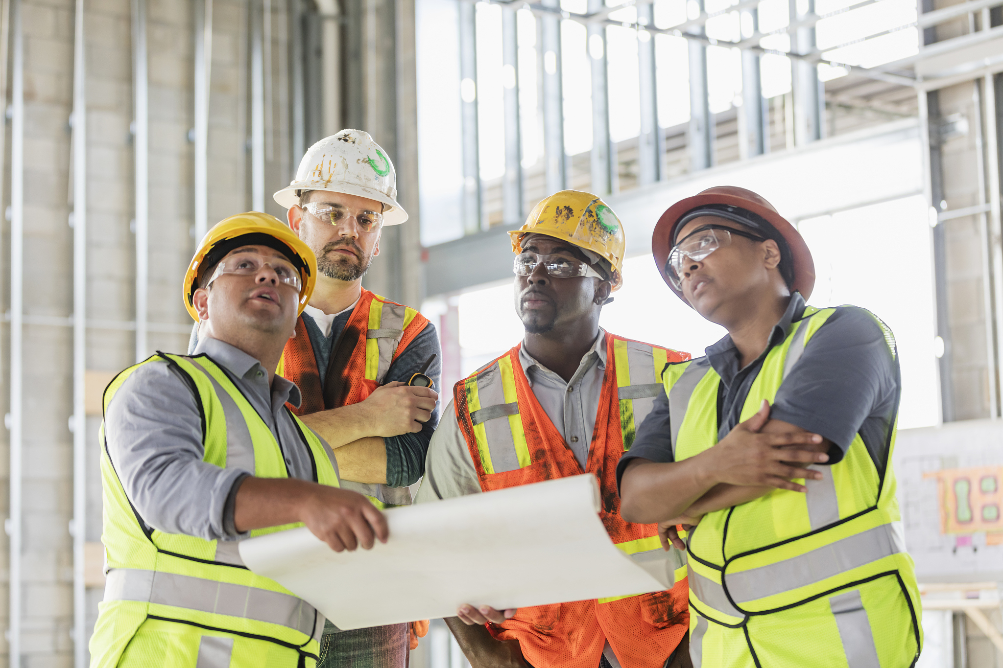 construction workers having meeting, with floor plans