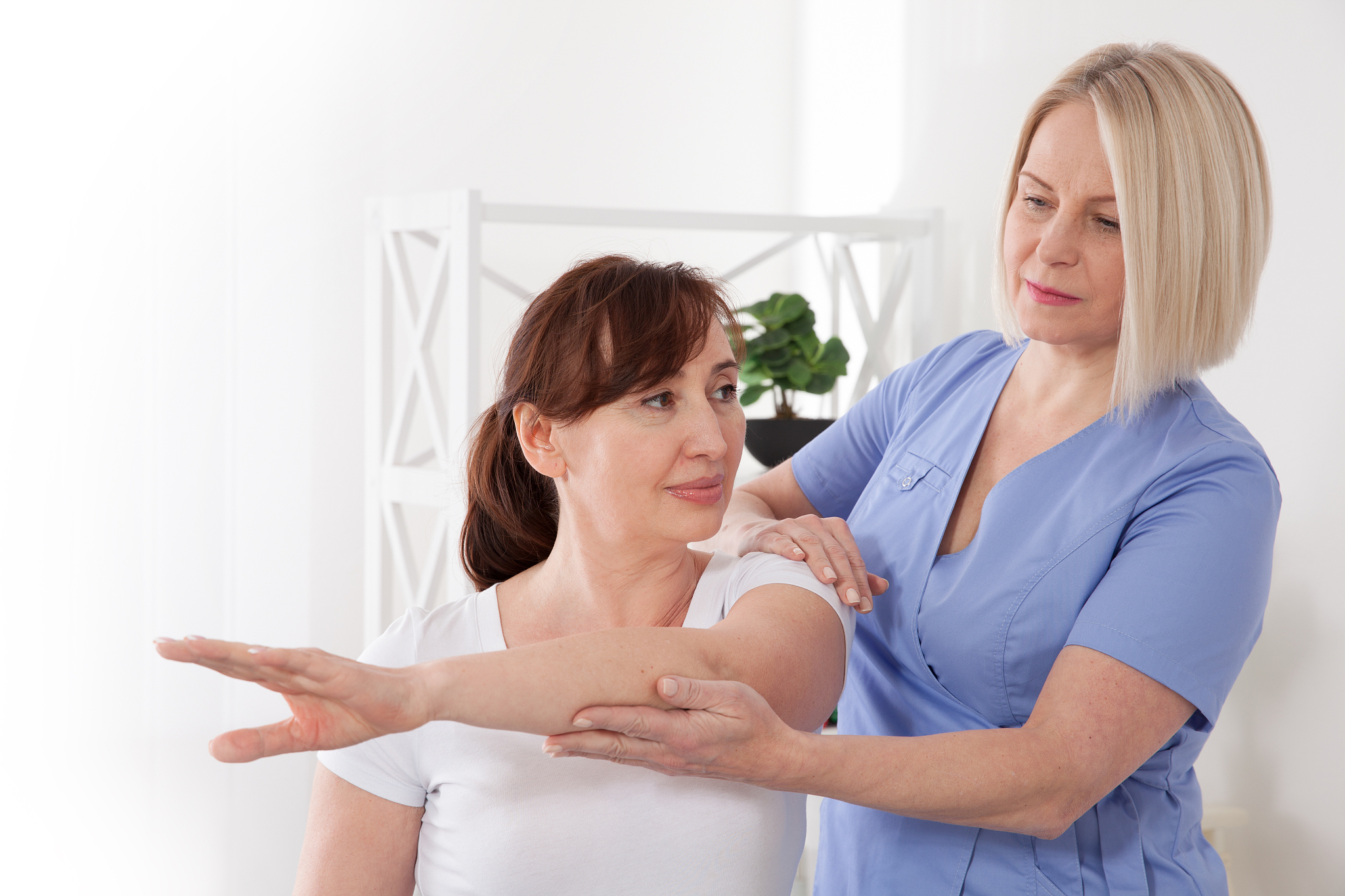 physiotherapist working with middle aged patient in clinic