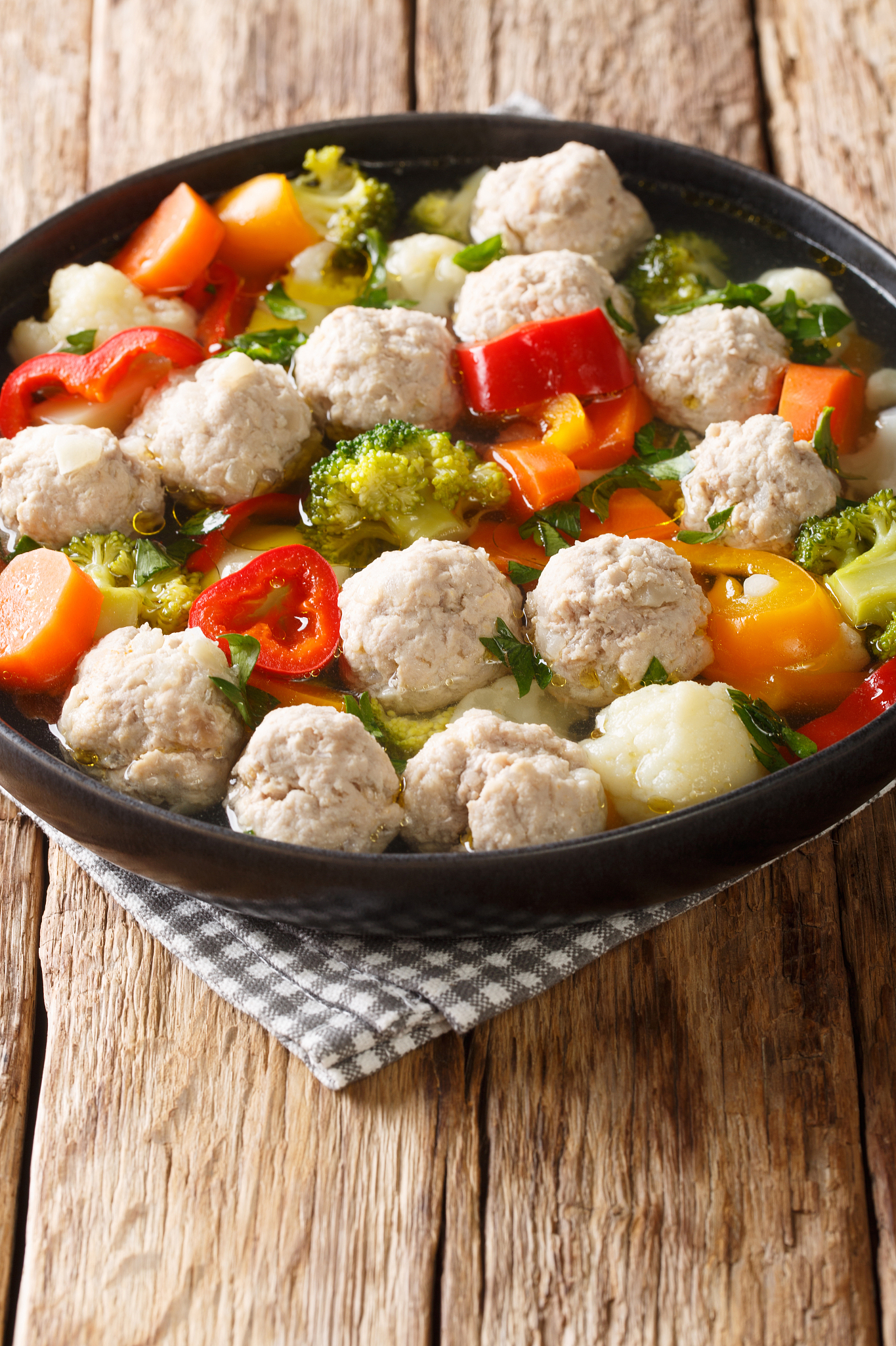 healthy soup with chicken meatballs and vegetables close-up in a