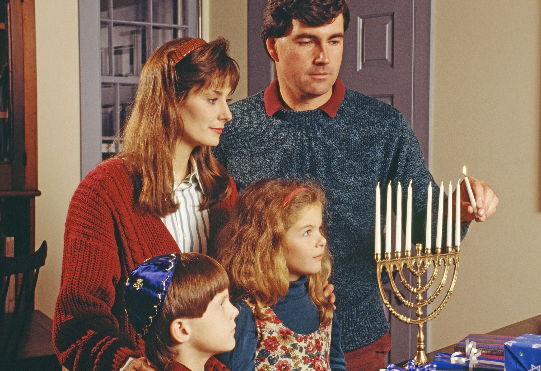 family lighting a menorah
