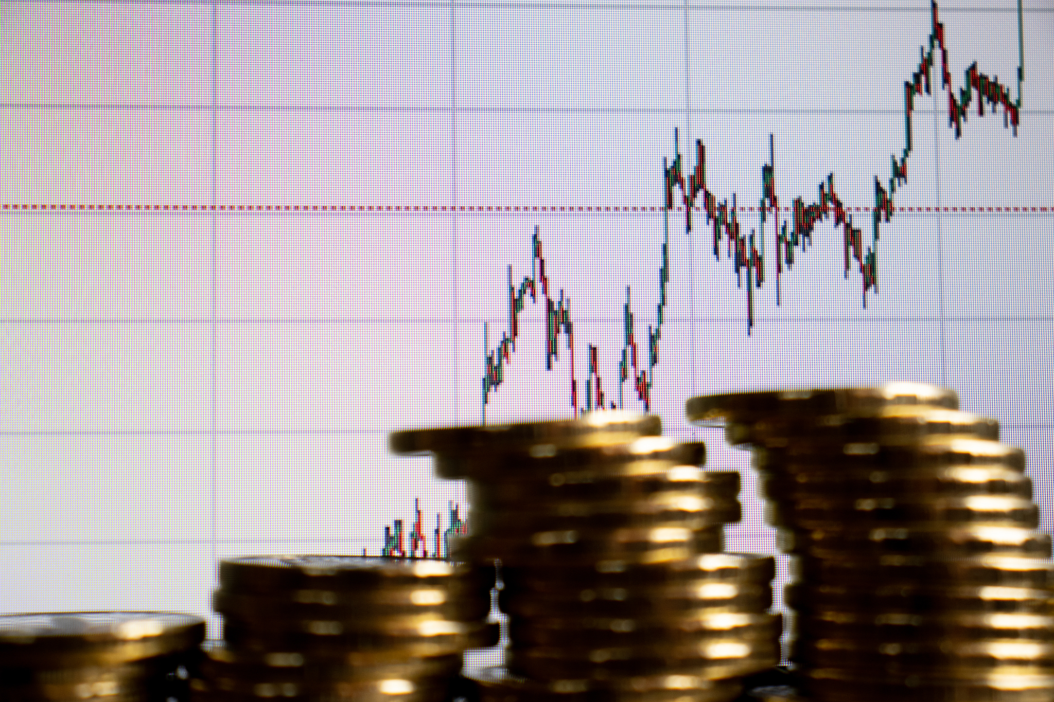 stacks of gold coins on financial chart background.