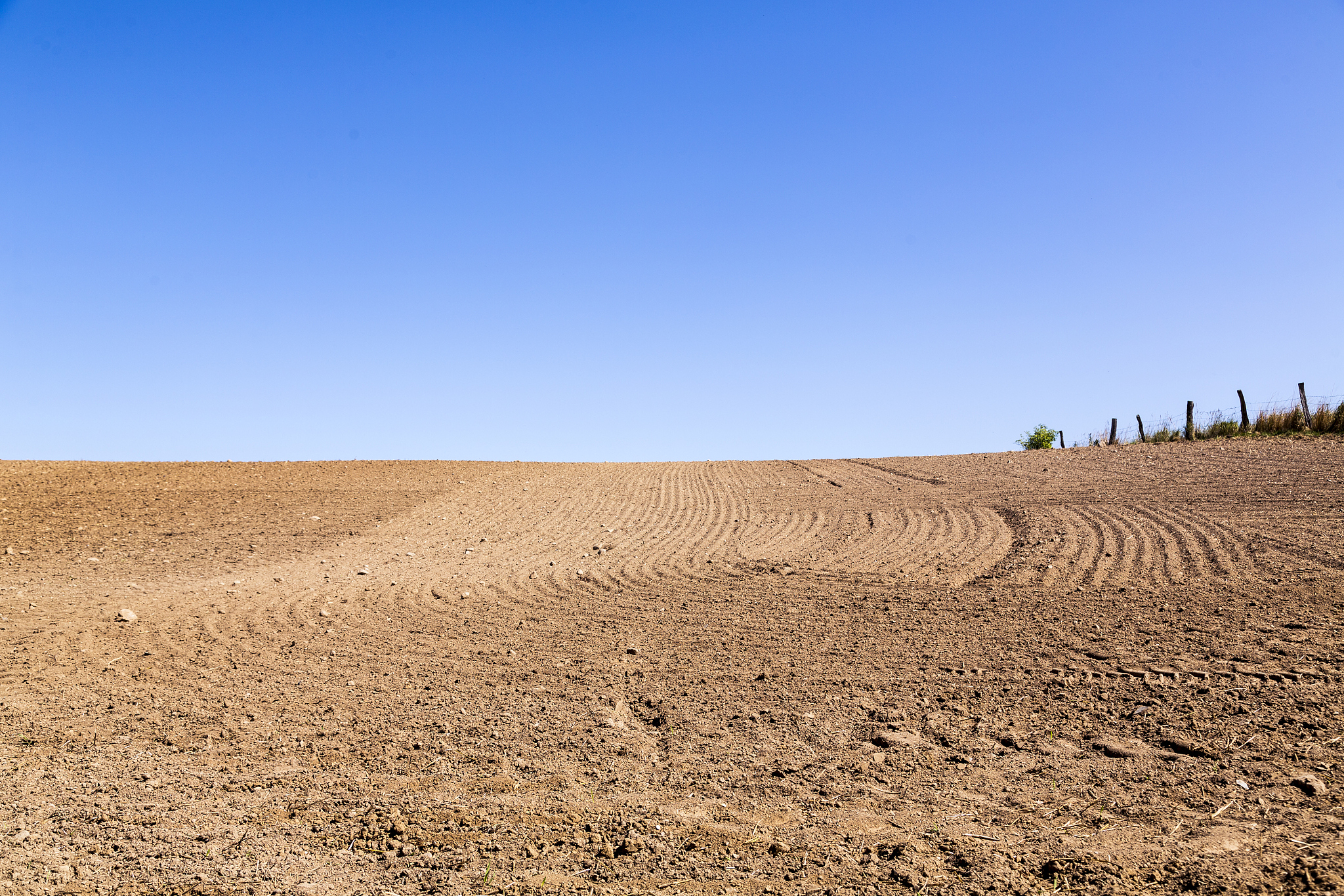 landscape with plowed field and blue sky