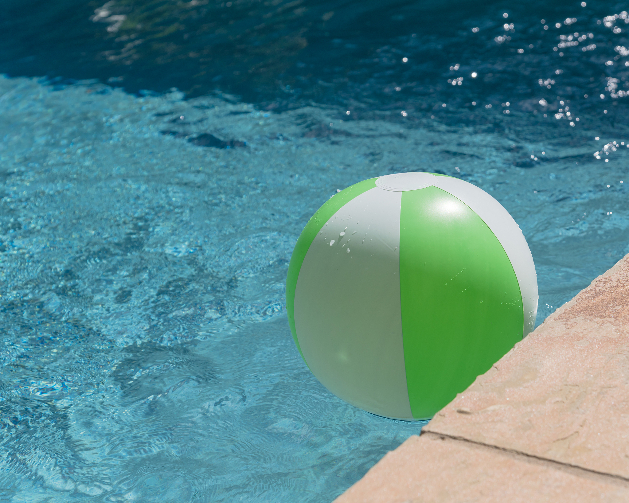 top view close-up beach ball near swimming pool coping