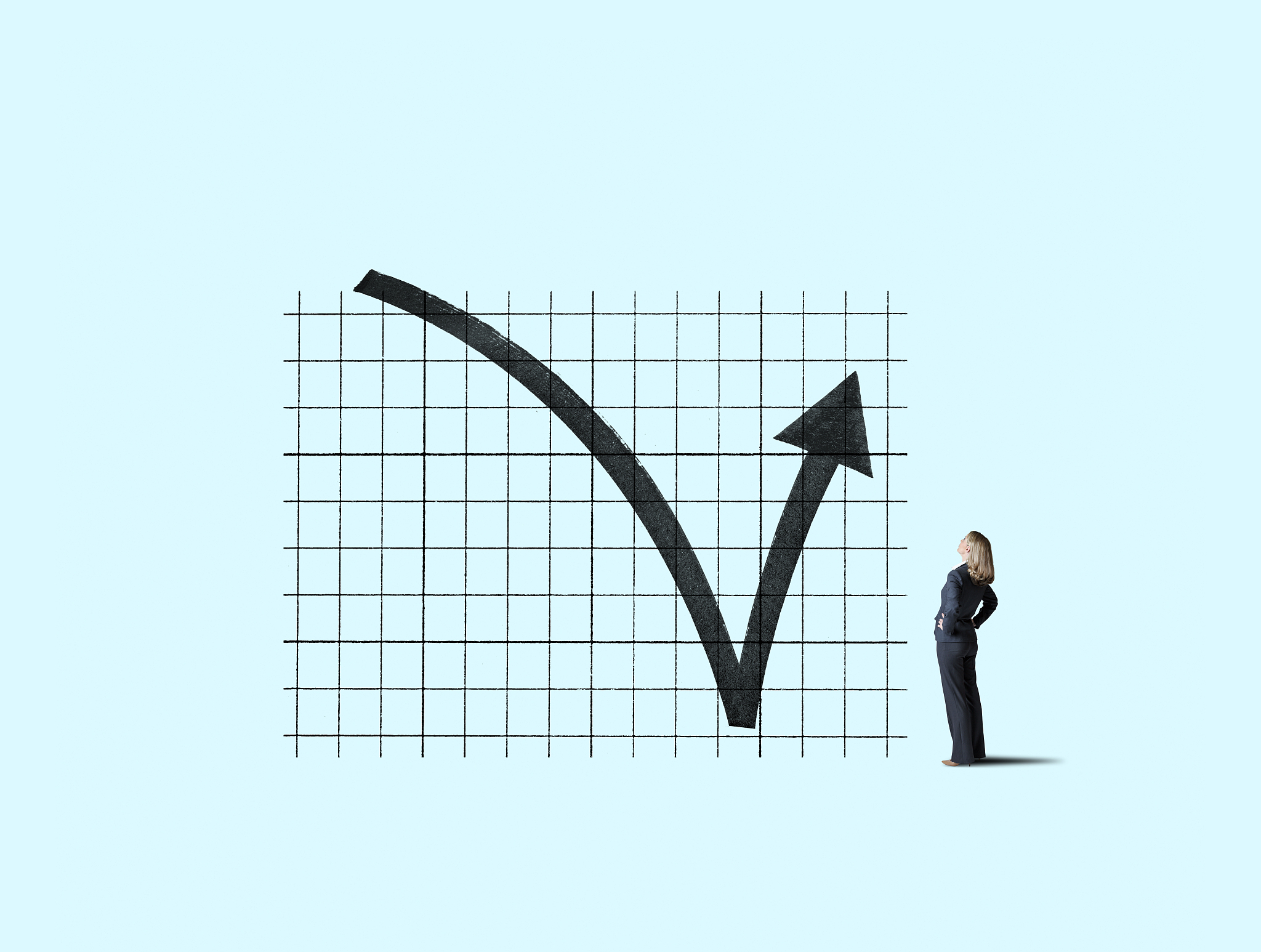 businesswoman looking up at chart that indicates a performance r